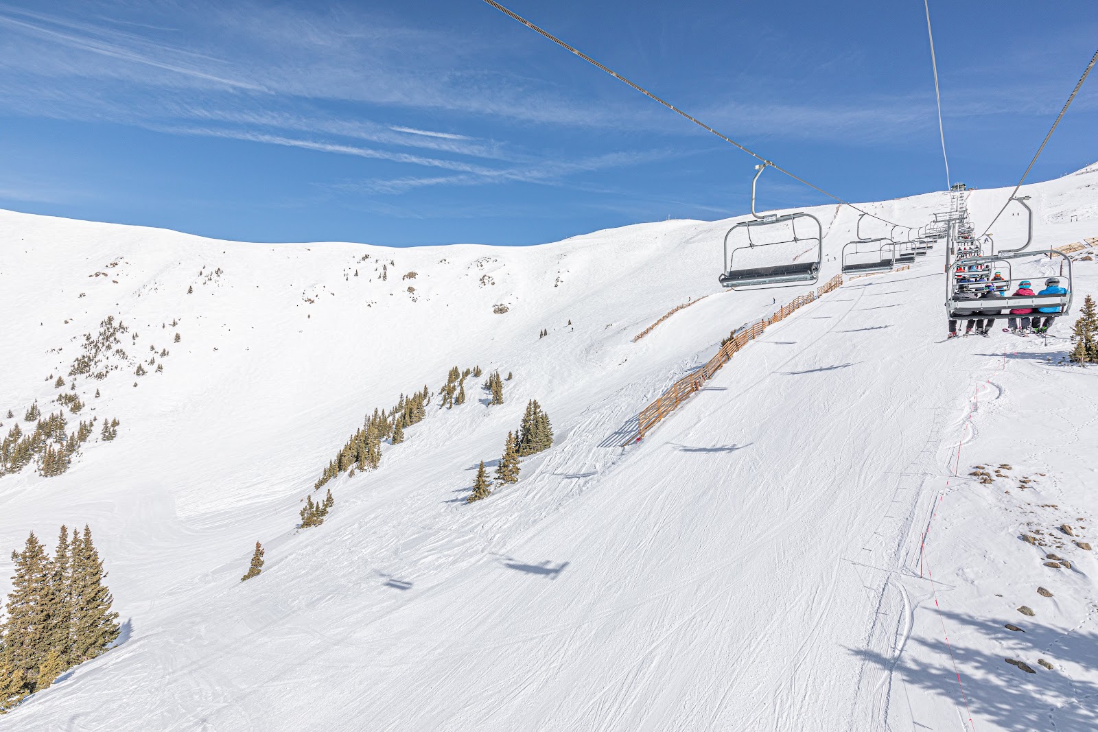 A skier on a high snow capped Colorado peak above the clouds