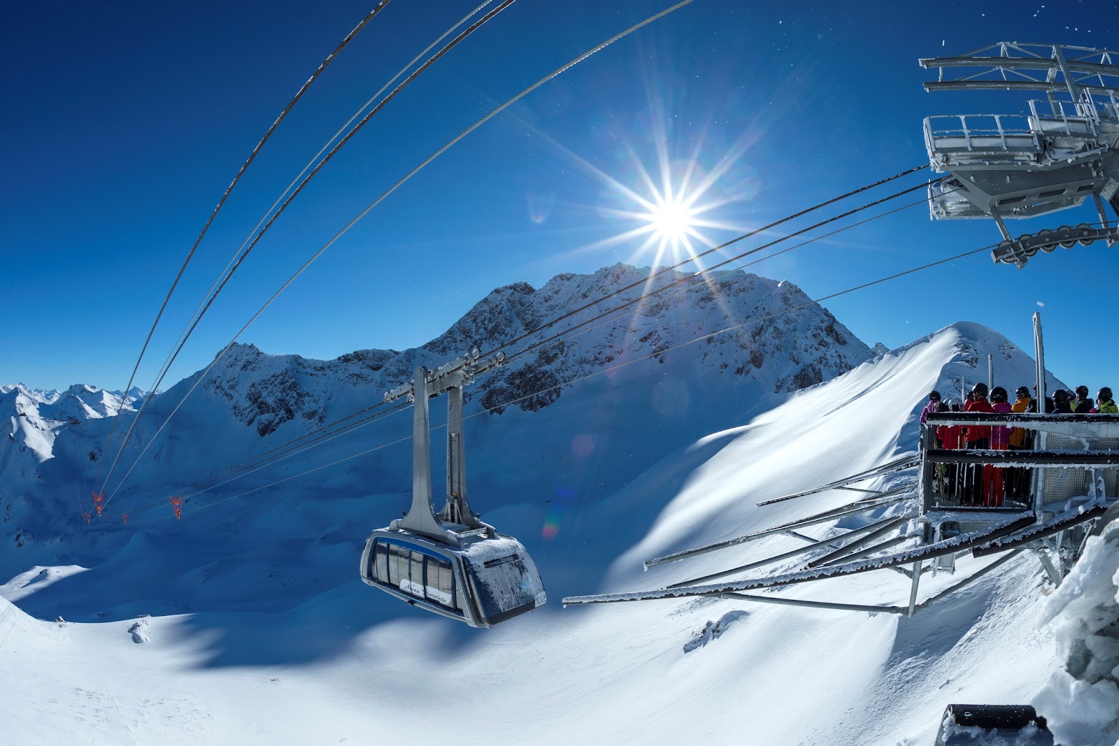 The sunny resort of Arosa around its frozen lake under winter peaks