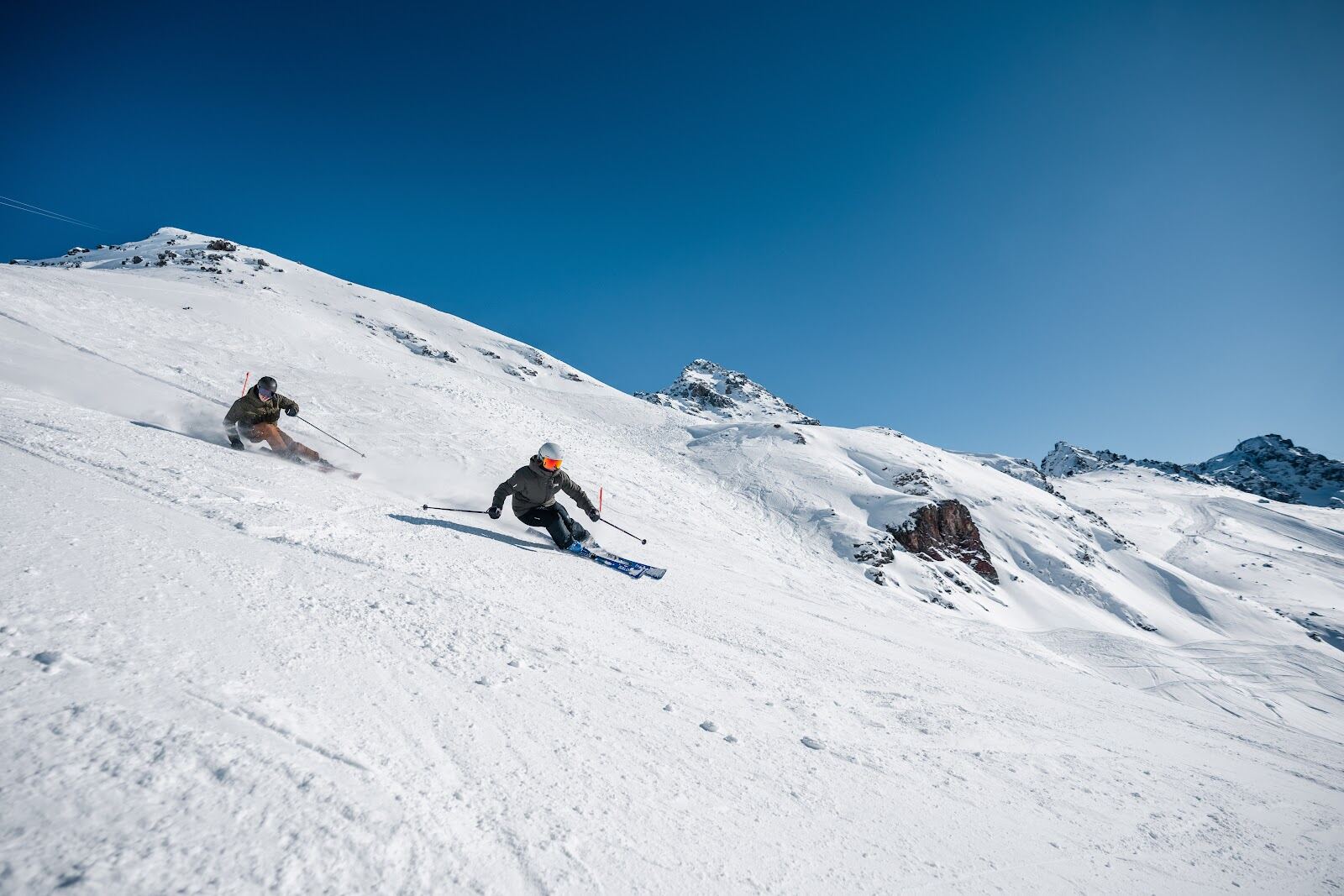 Skiers on a wide sunny piste above Arosa