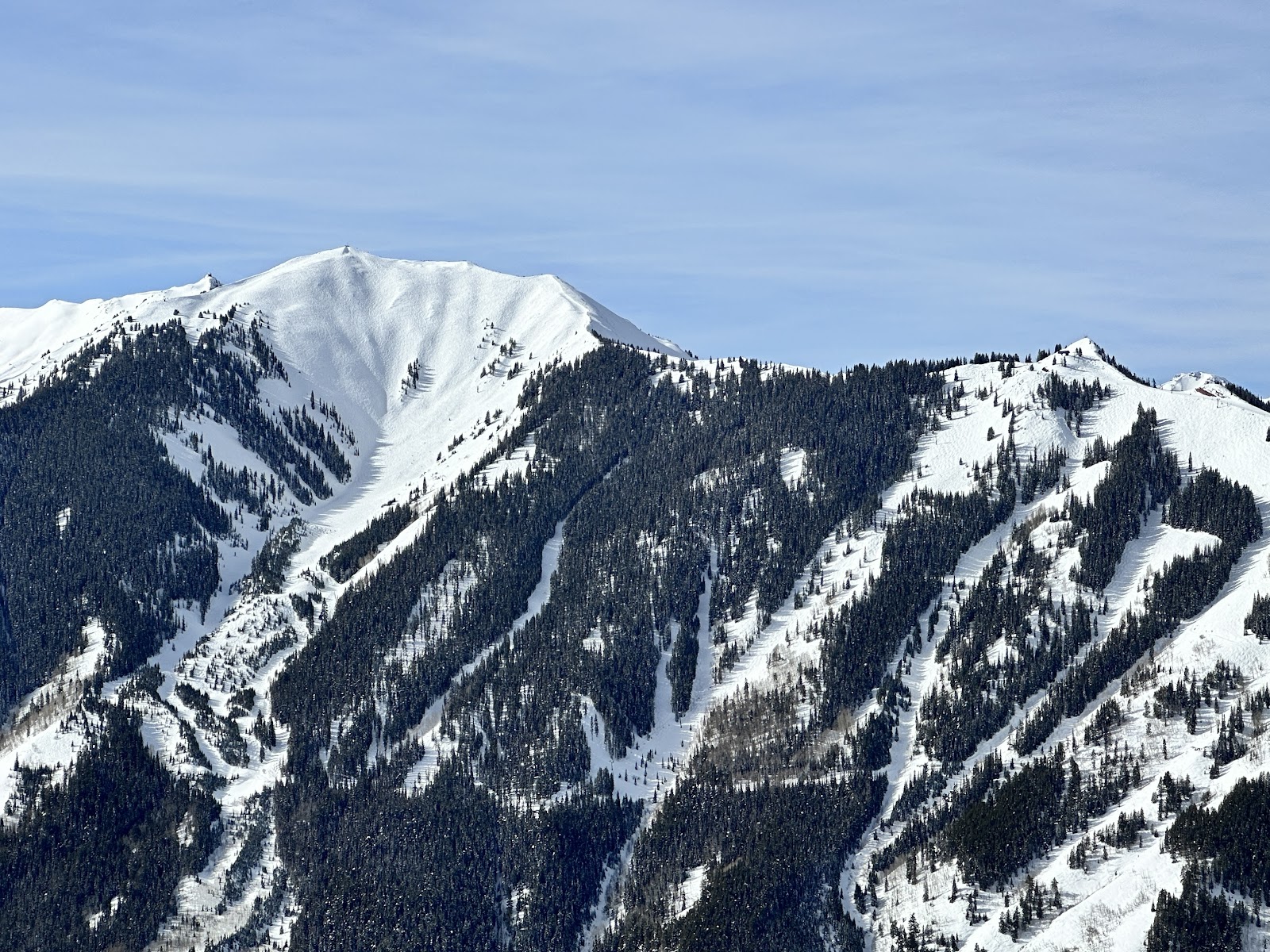 A skier in deep powder on a steep North American face