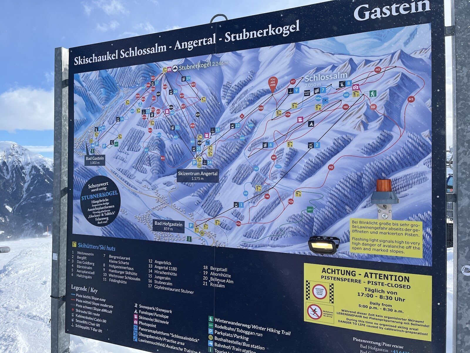 Skiers on a wide red piste above the Gastein valley