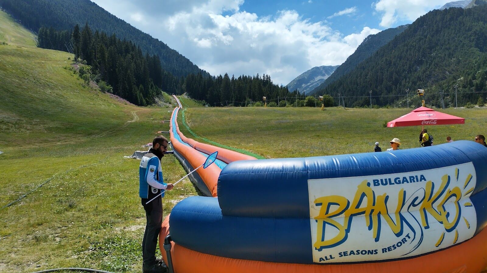 Skiers on a groomed intermediate piste at Bansko