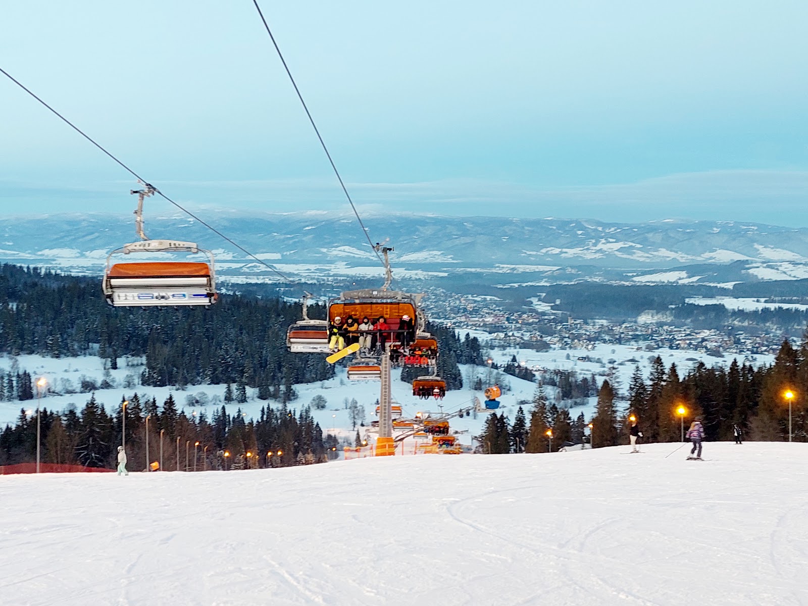 A modern chairlift over snowmaking covered slopes at Bialka Tatrzanska