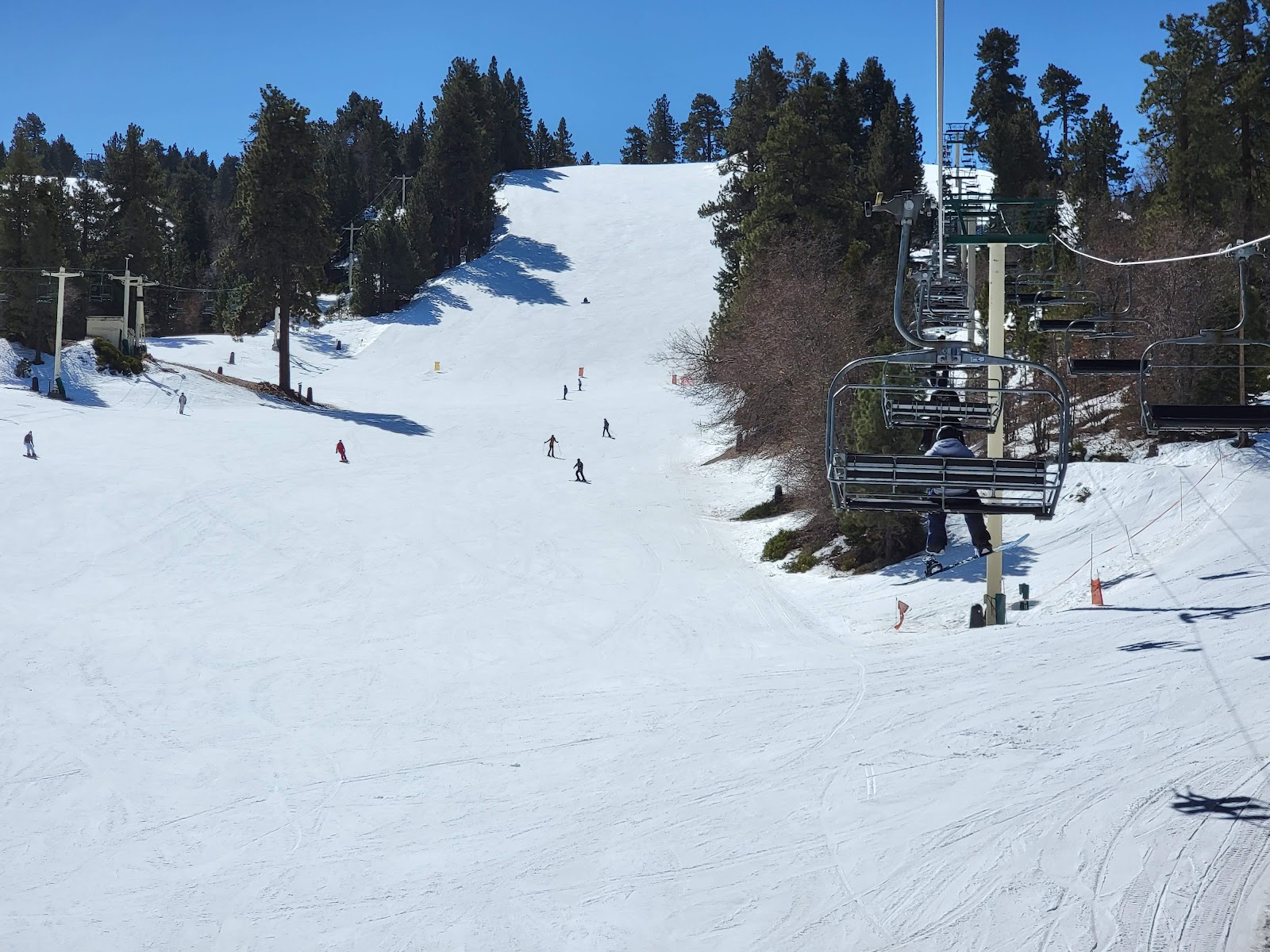 A snowboarder hitting a jump in the terrain park at Bear Mountain