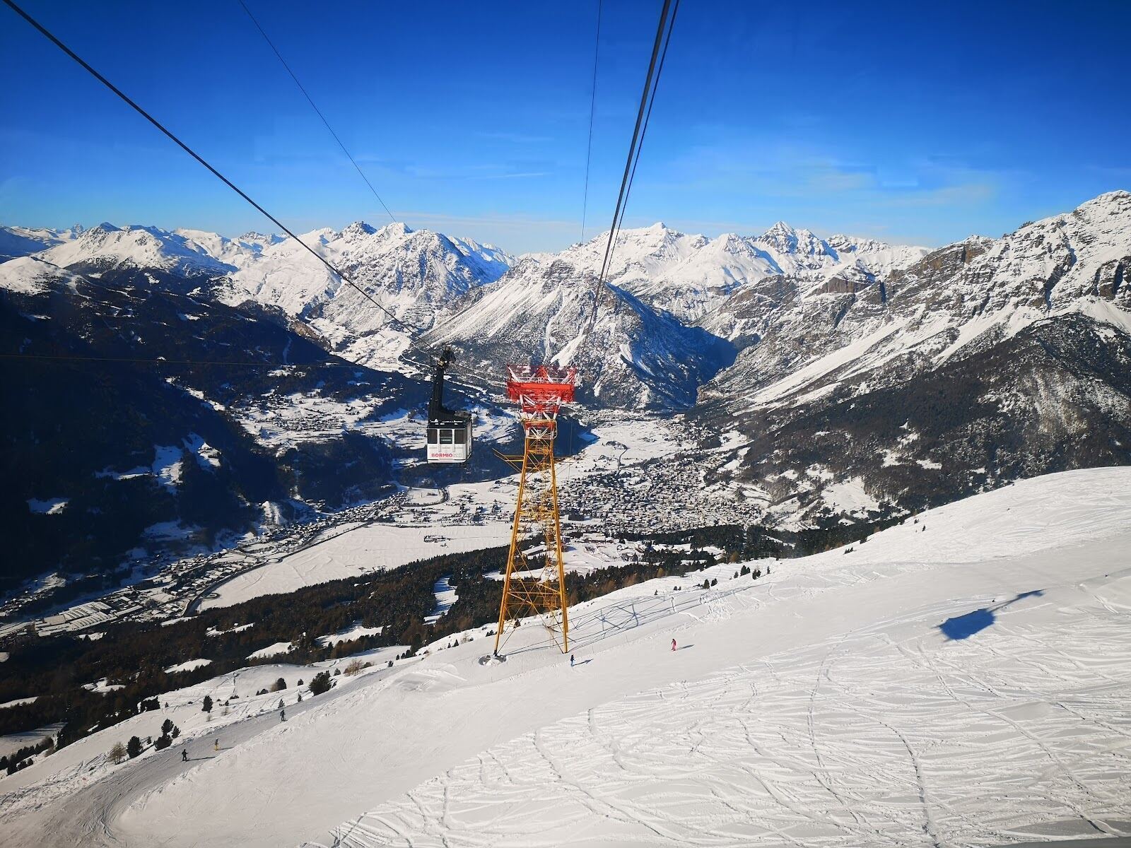 Long steep pistes descending toward the historic town of Bormio in winter