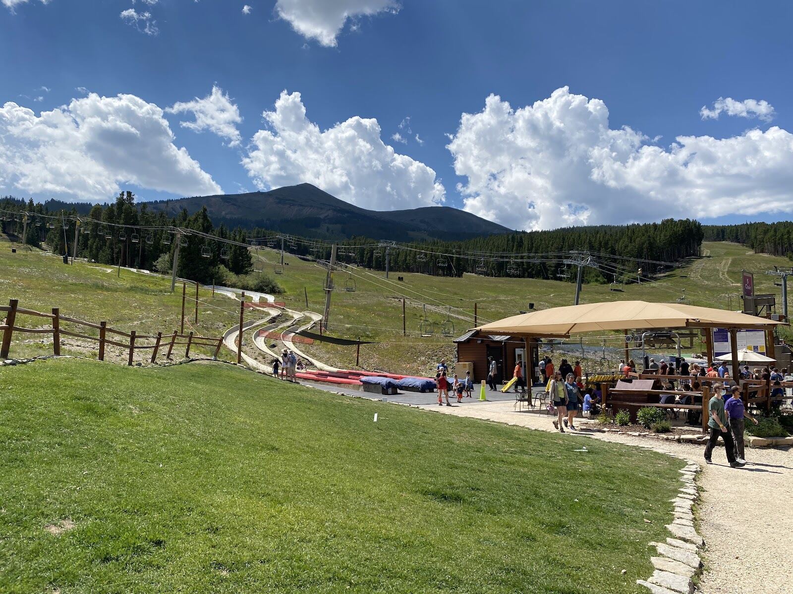 Skiers on a wide groomed blue run across the peaks of Breckenridge