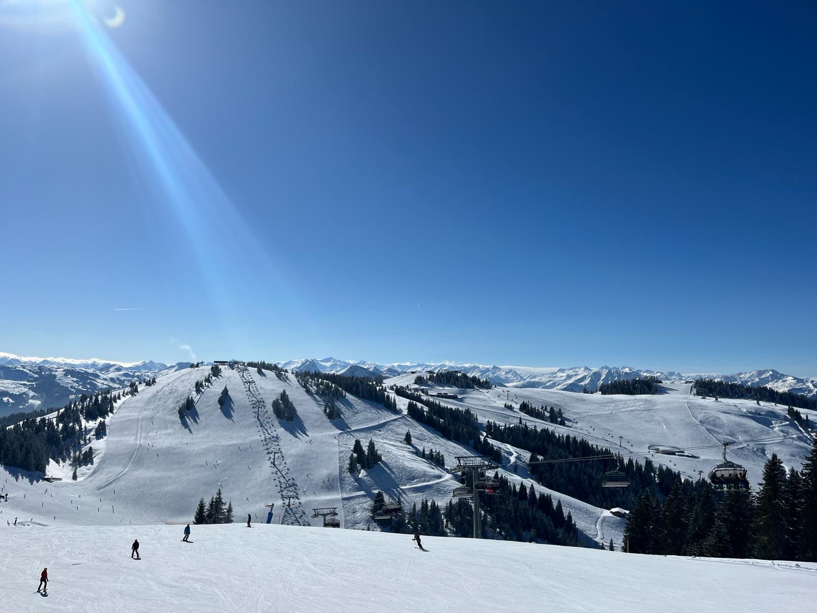 Wide well groomed SkiWelt pistes above Brixen im Thale in sunshine