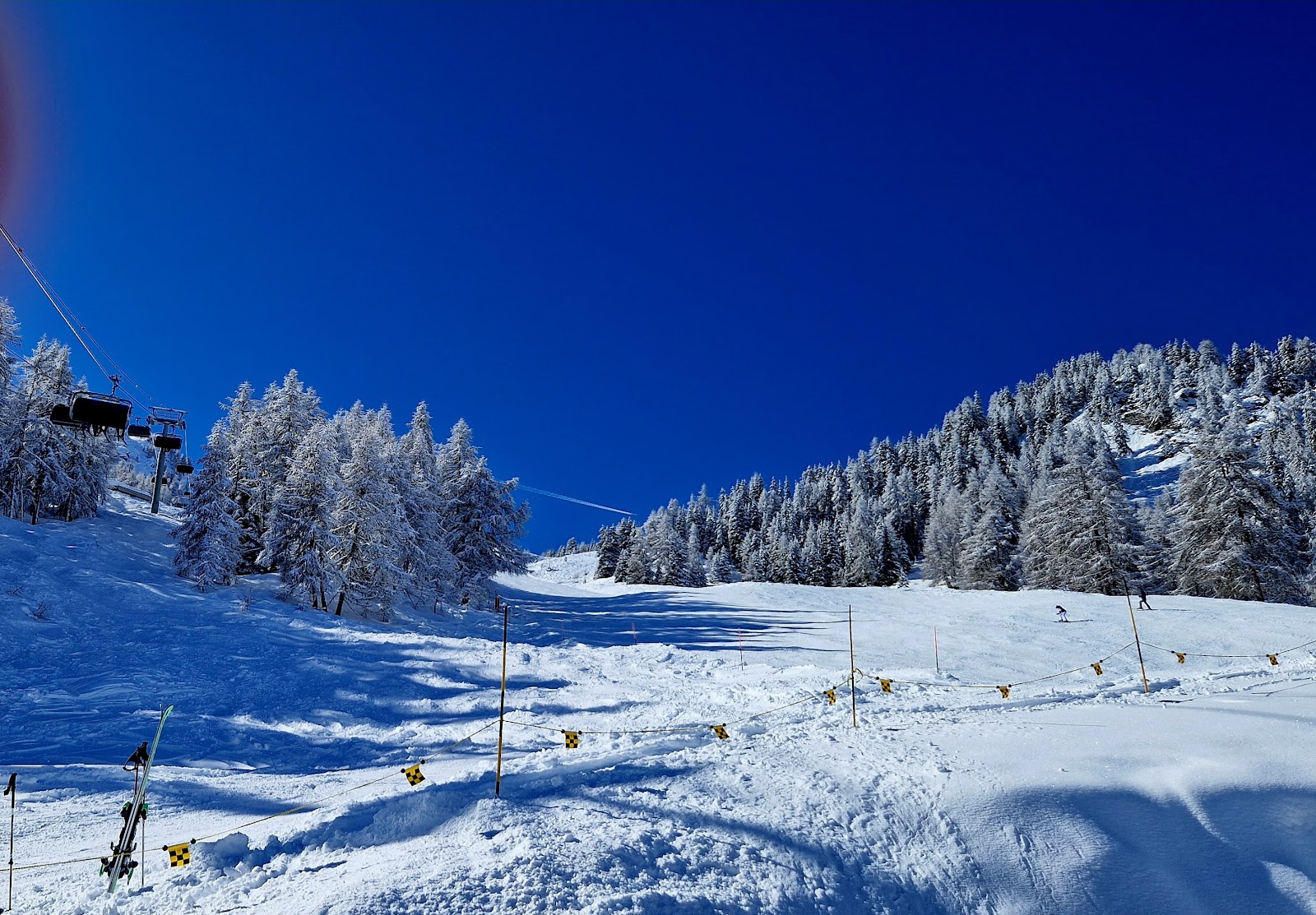 Skiers on an empty north facing piste above Bruson