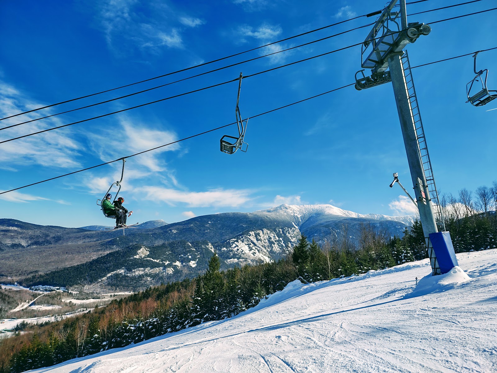 A skier carving a turn on a sunlit groomed run