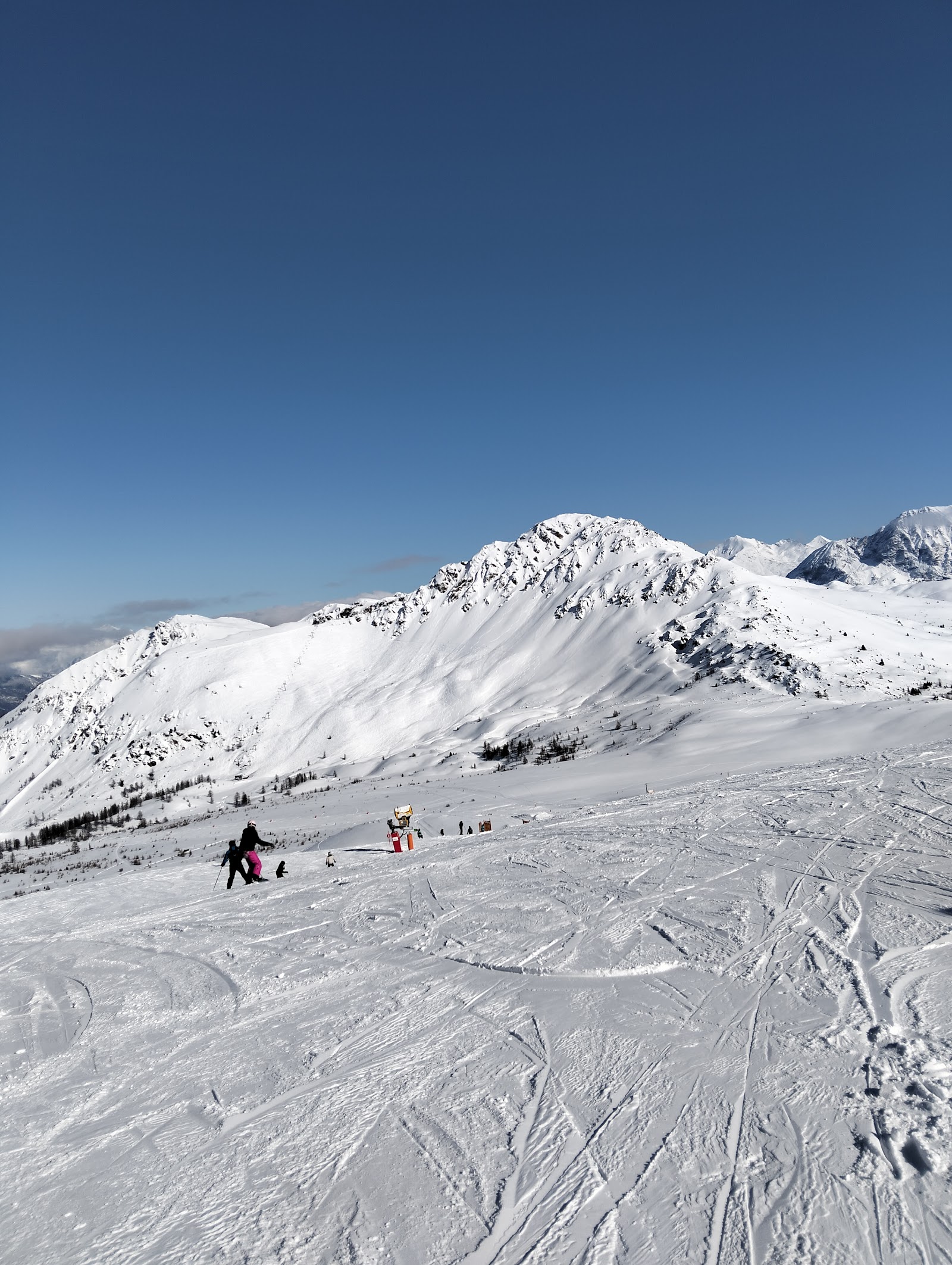 Skiers cruising a wide groomed run on the Milky Way