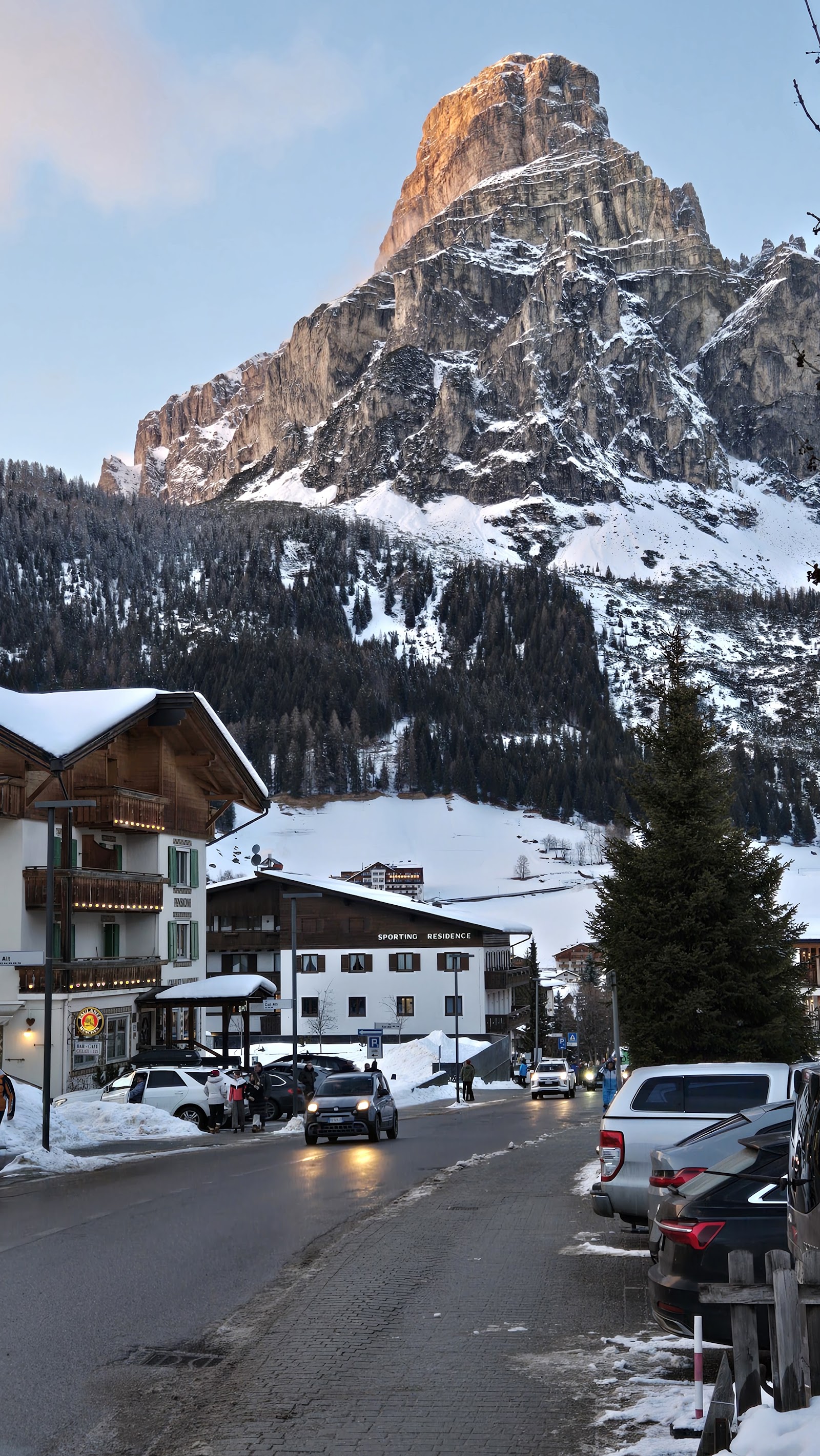 A skier on a long groomed Dolomites run in clear weather
