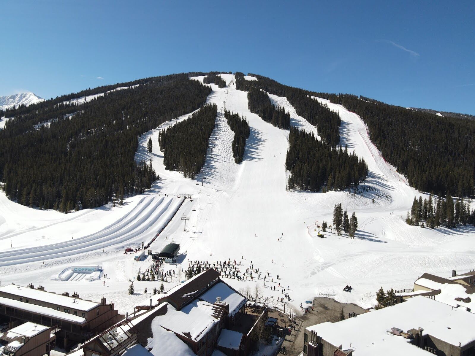 Chairlift rising over snowy pistes at Copper Mountain village