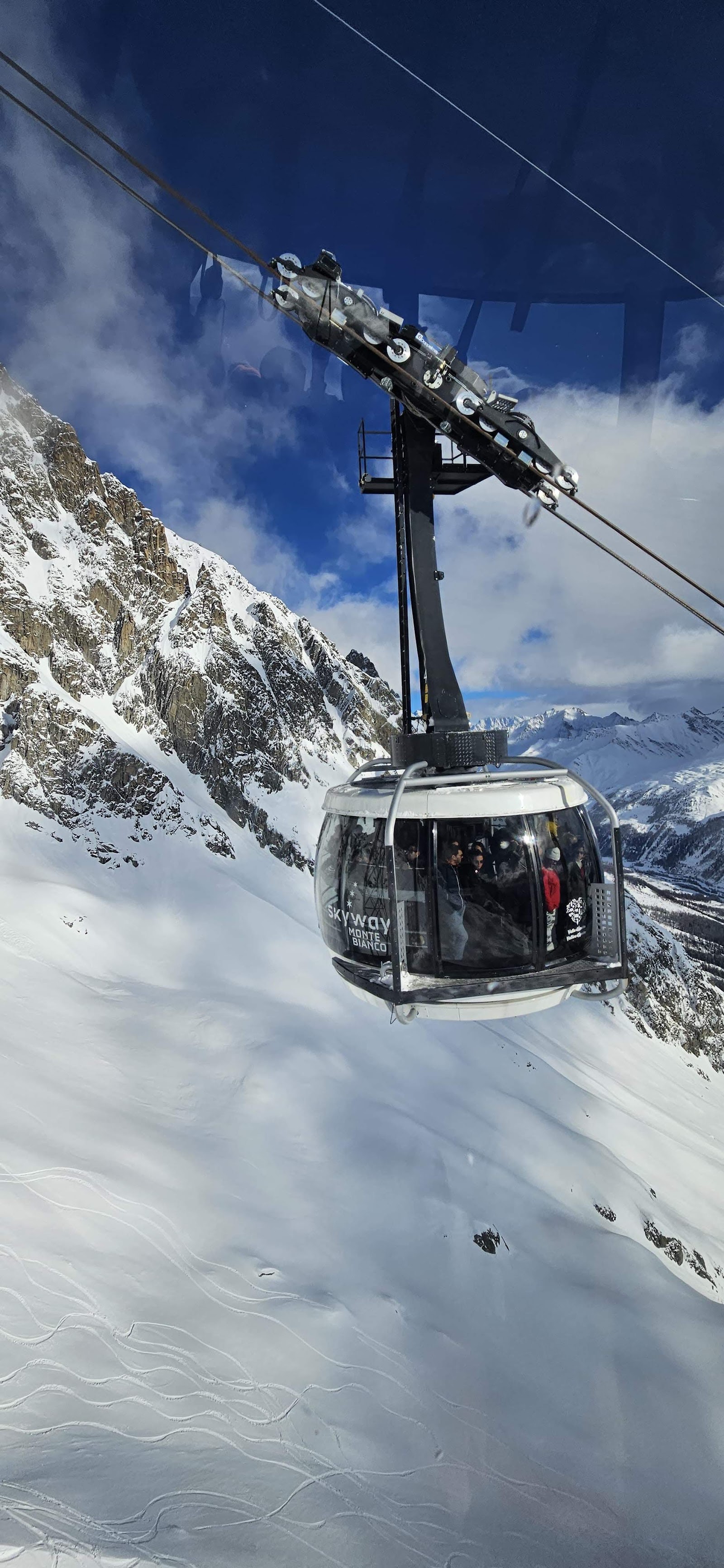 The peaks of the Mont Blanc massif rising above the ski pistes of Courmayeur in Italy
