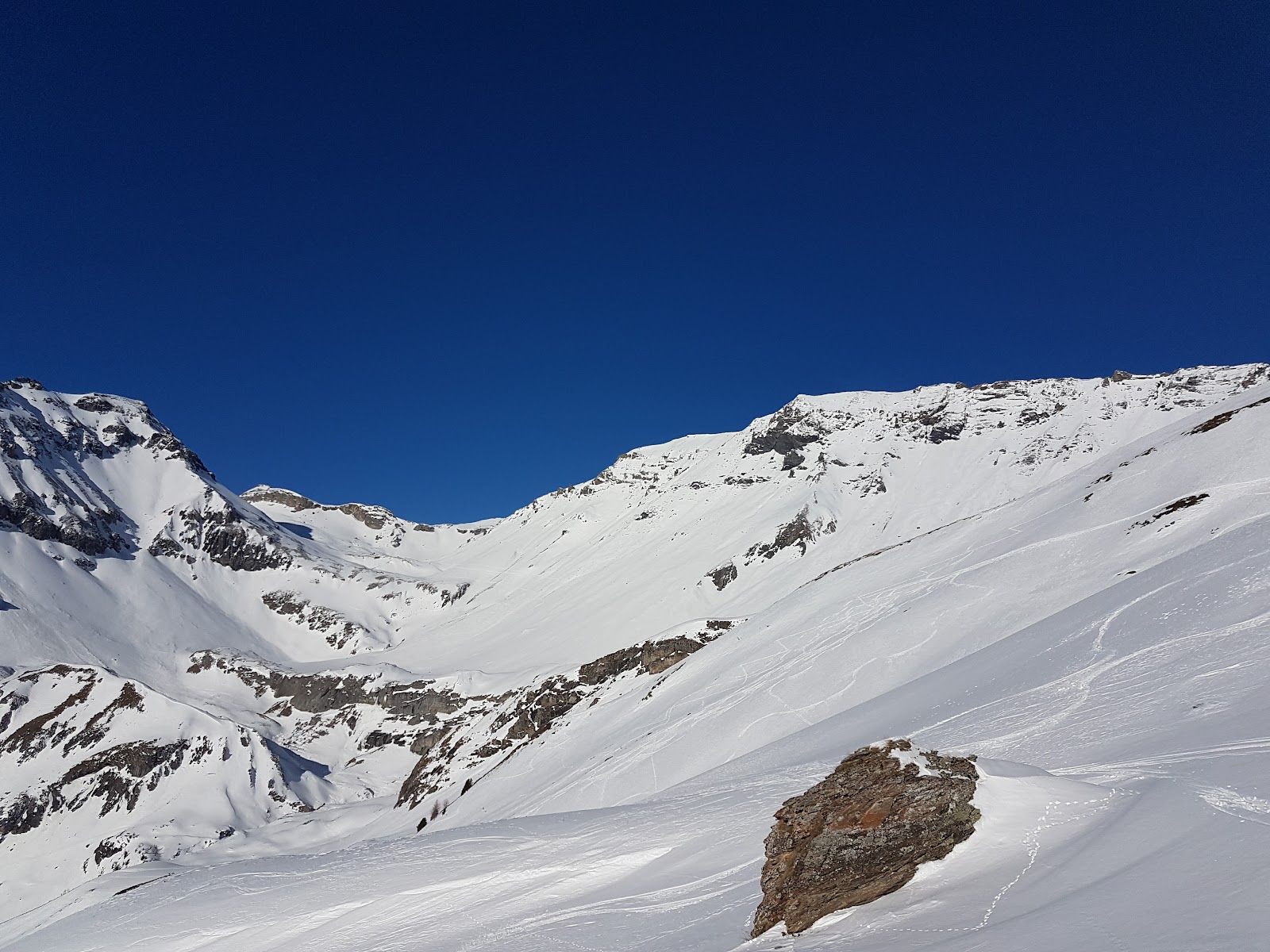 The modern town of Crans Montana spread along its sunny plateau with mountains behind