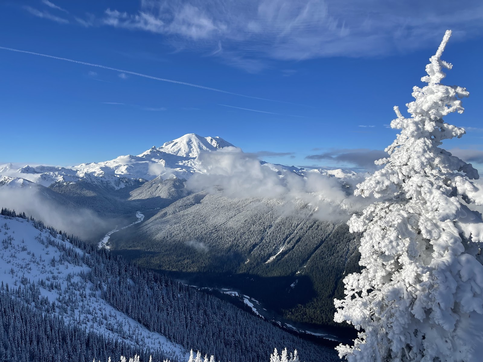 Snowy peaks and chairlifts at Crystal Mountain Washington with Mount Rainier behind