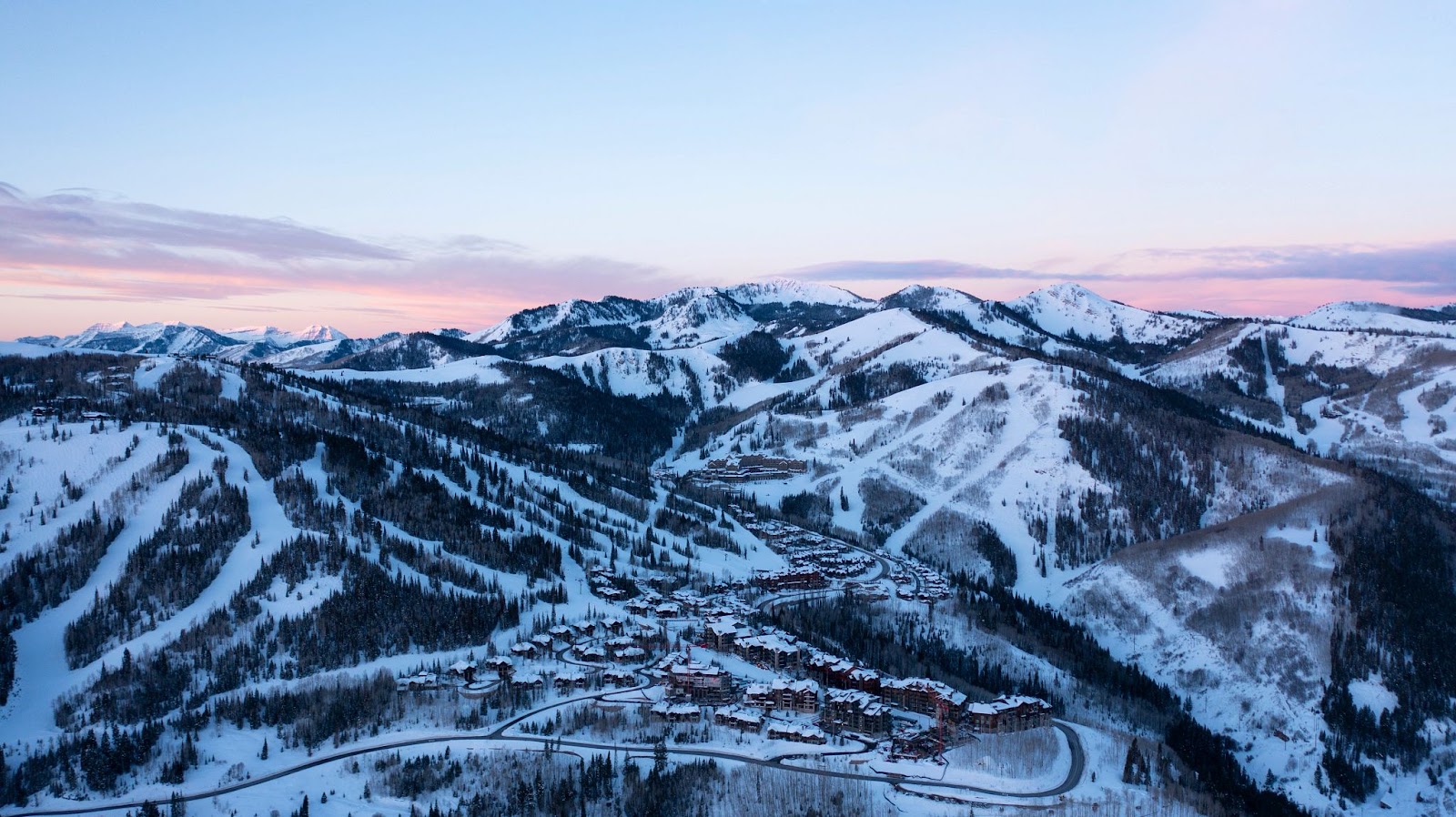 A skier on uncrowded blue runs at Deer Valley under blue Utah sky