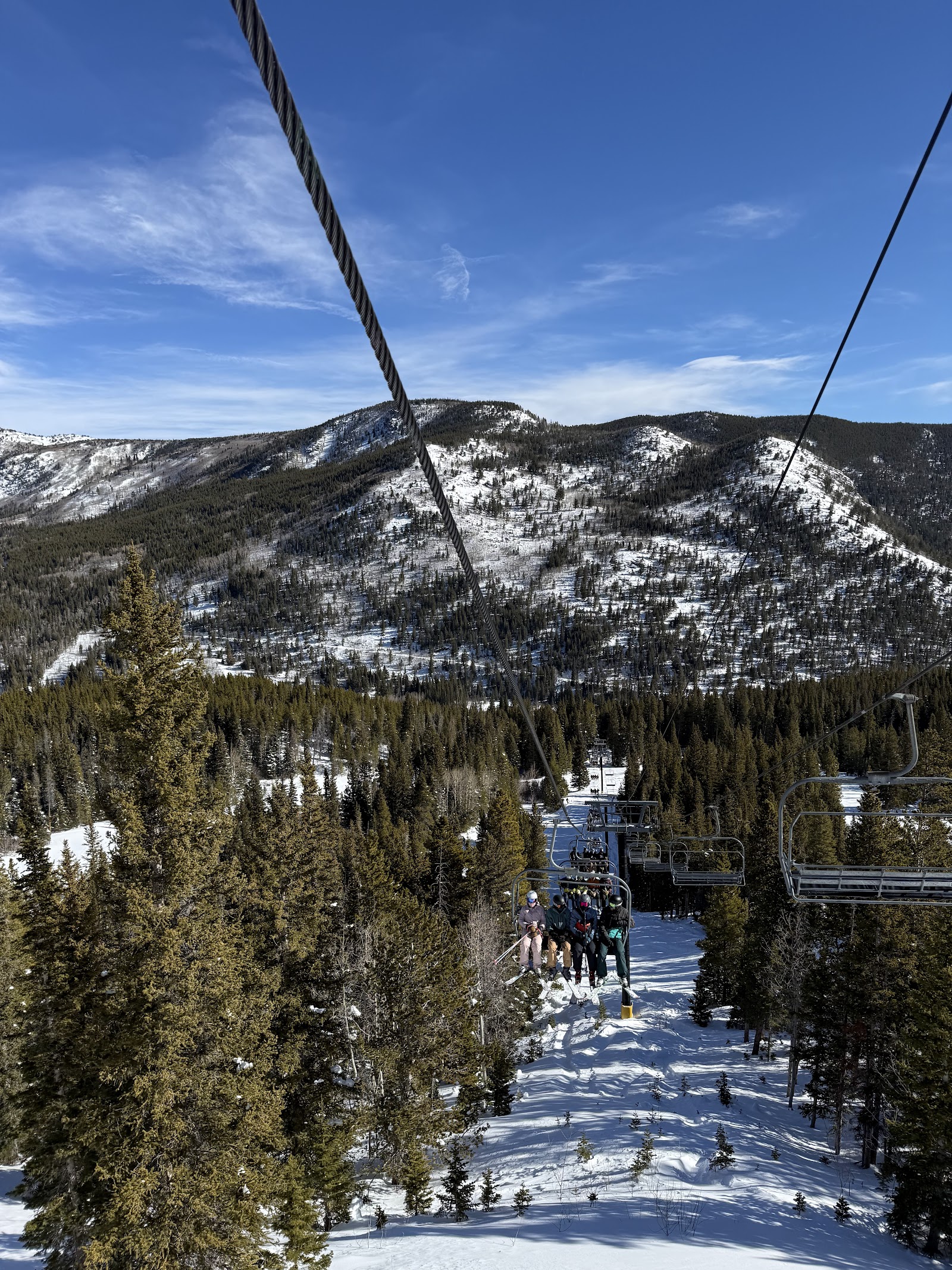 Ski chairlift climbing a sunny Colorado piste