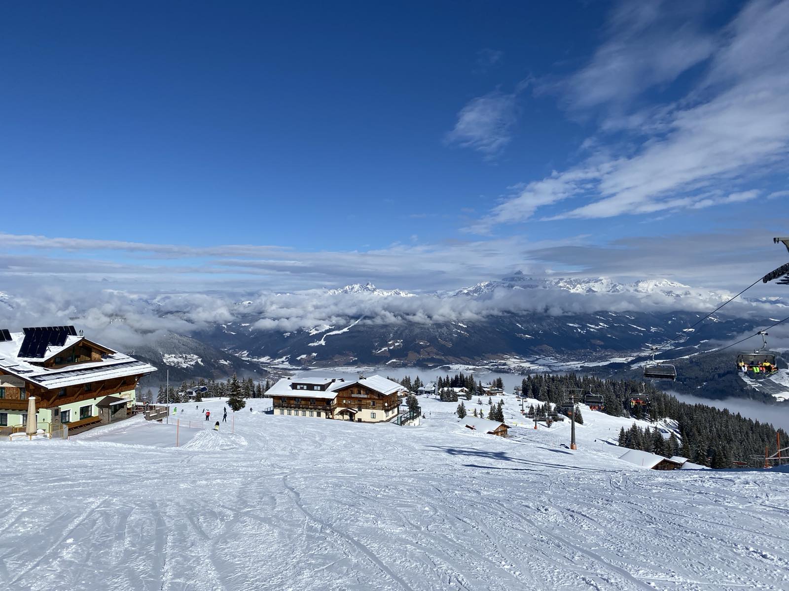 A floodlit ski slope above a village at night