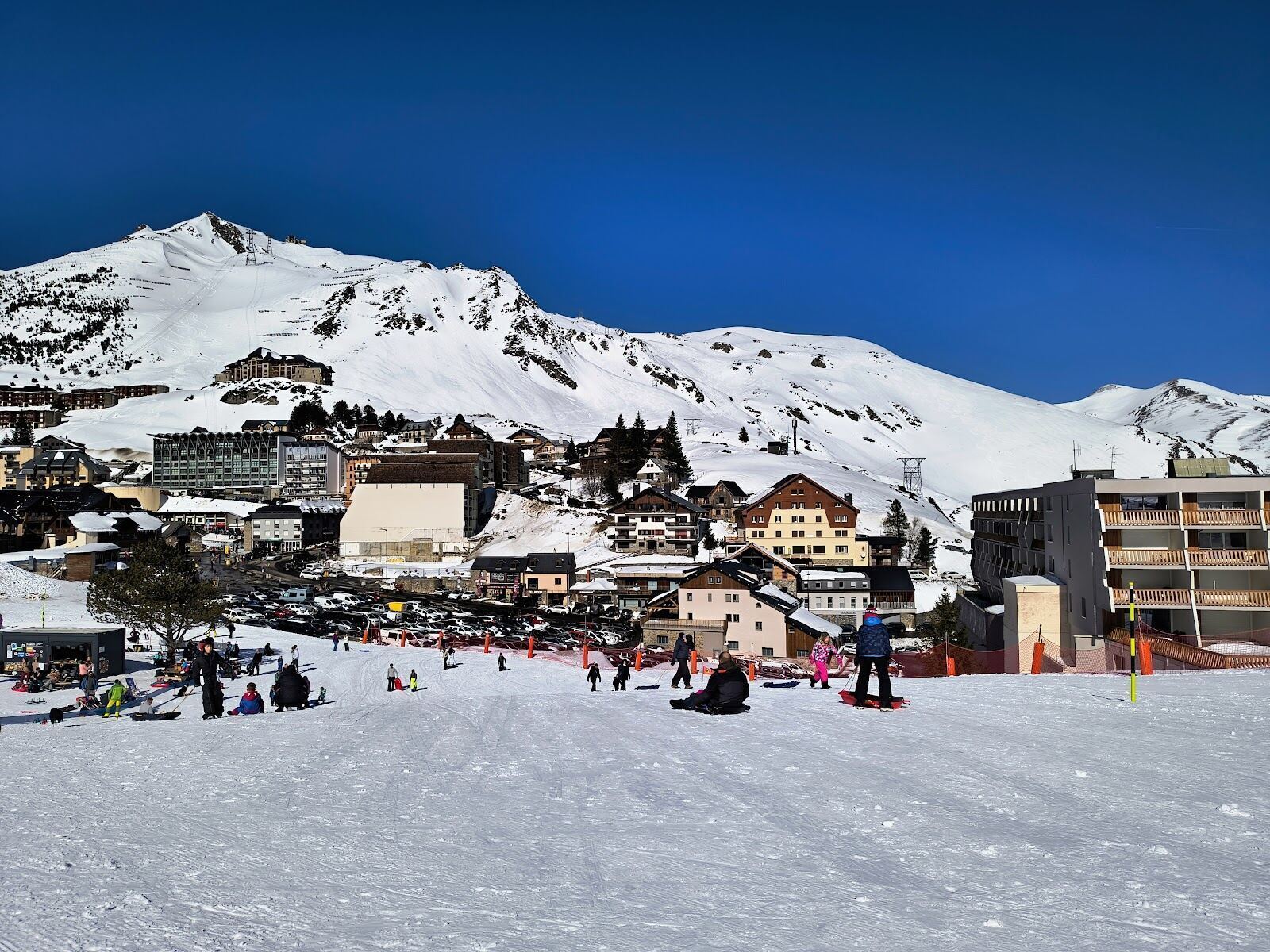 Skiers on a wide piste in the La Mongie bowl