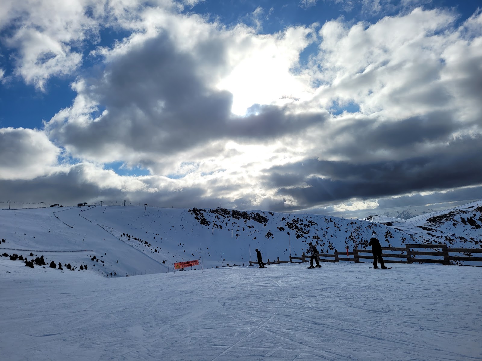 Skiers on wide open pisted runs above Soldeu in Grandvalira