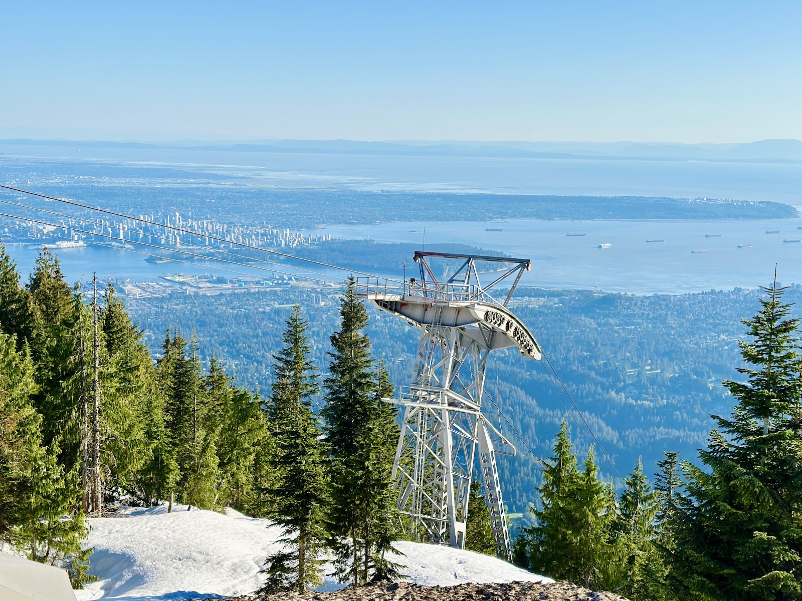 Skiers on a gentle groomed run with the city skyline beyond