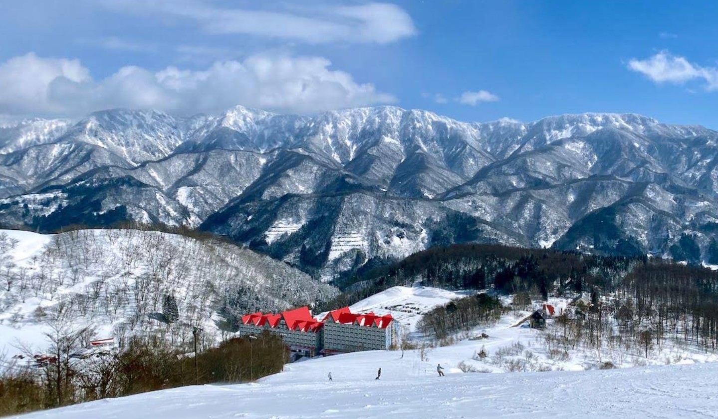 The landmark base hotel and snowy slopes at Hakuba Cortina