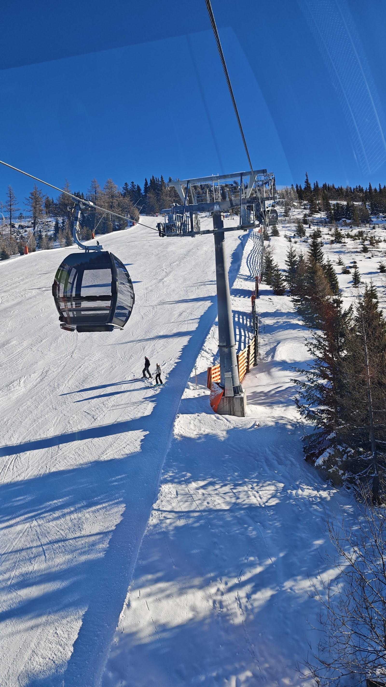 Skiers on gentle sunny pistes above Katschberg