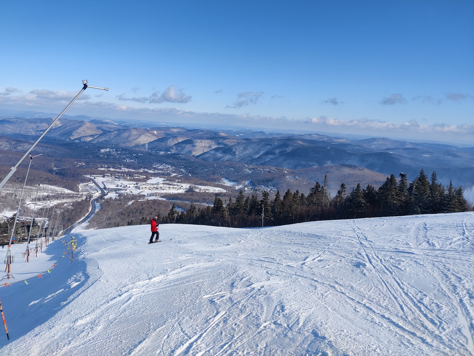 Skiers carving groomed corduroy on a sunny morning at Killington