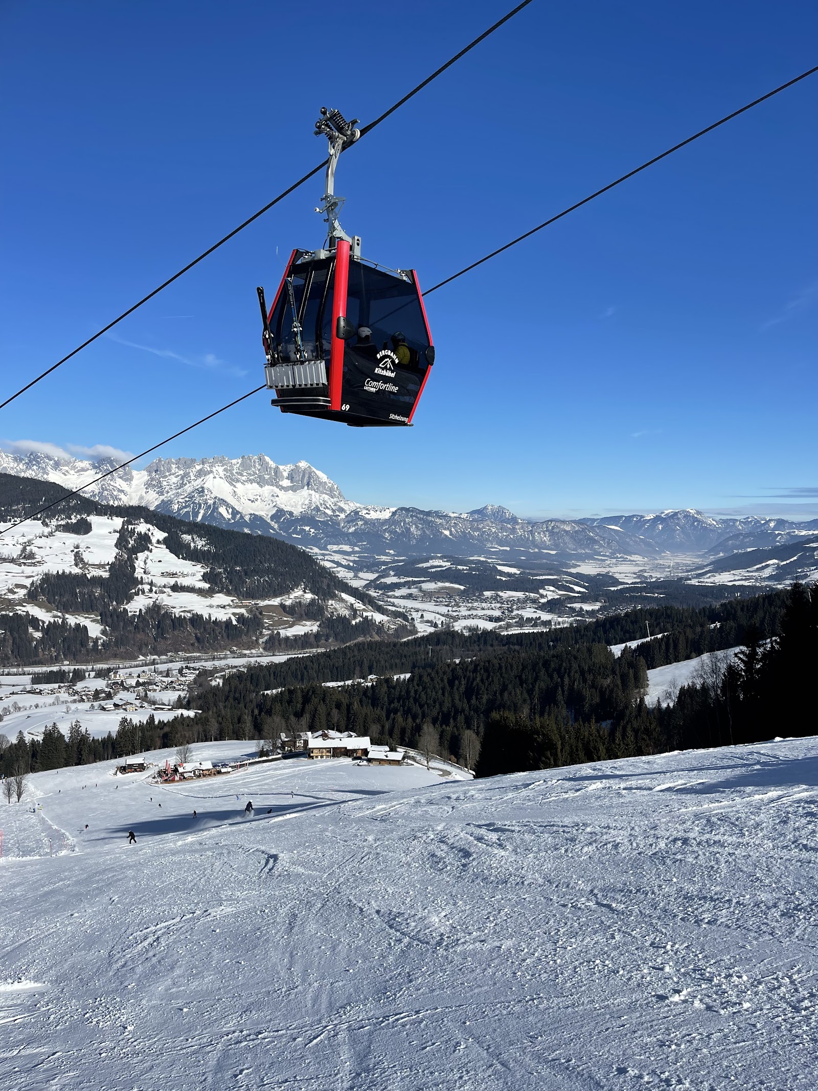 Skiers on a sunny groomed run in the Kitzbuhel Alps
