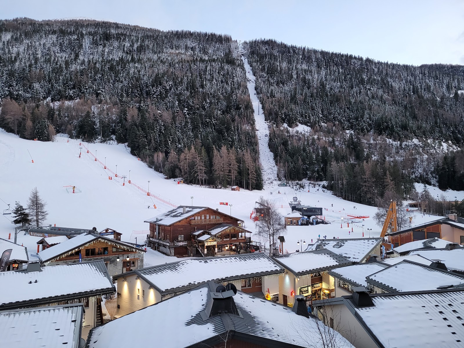 Pedestrian village square at La Norma with chalets and snow