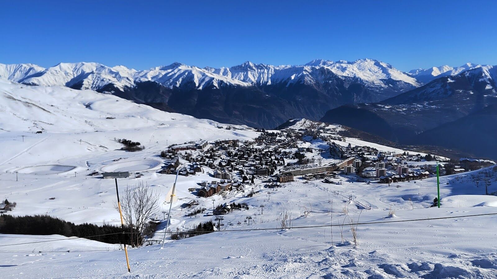 The open sunny plateau and modern chalets of La Toussuire under snow