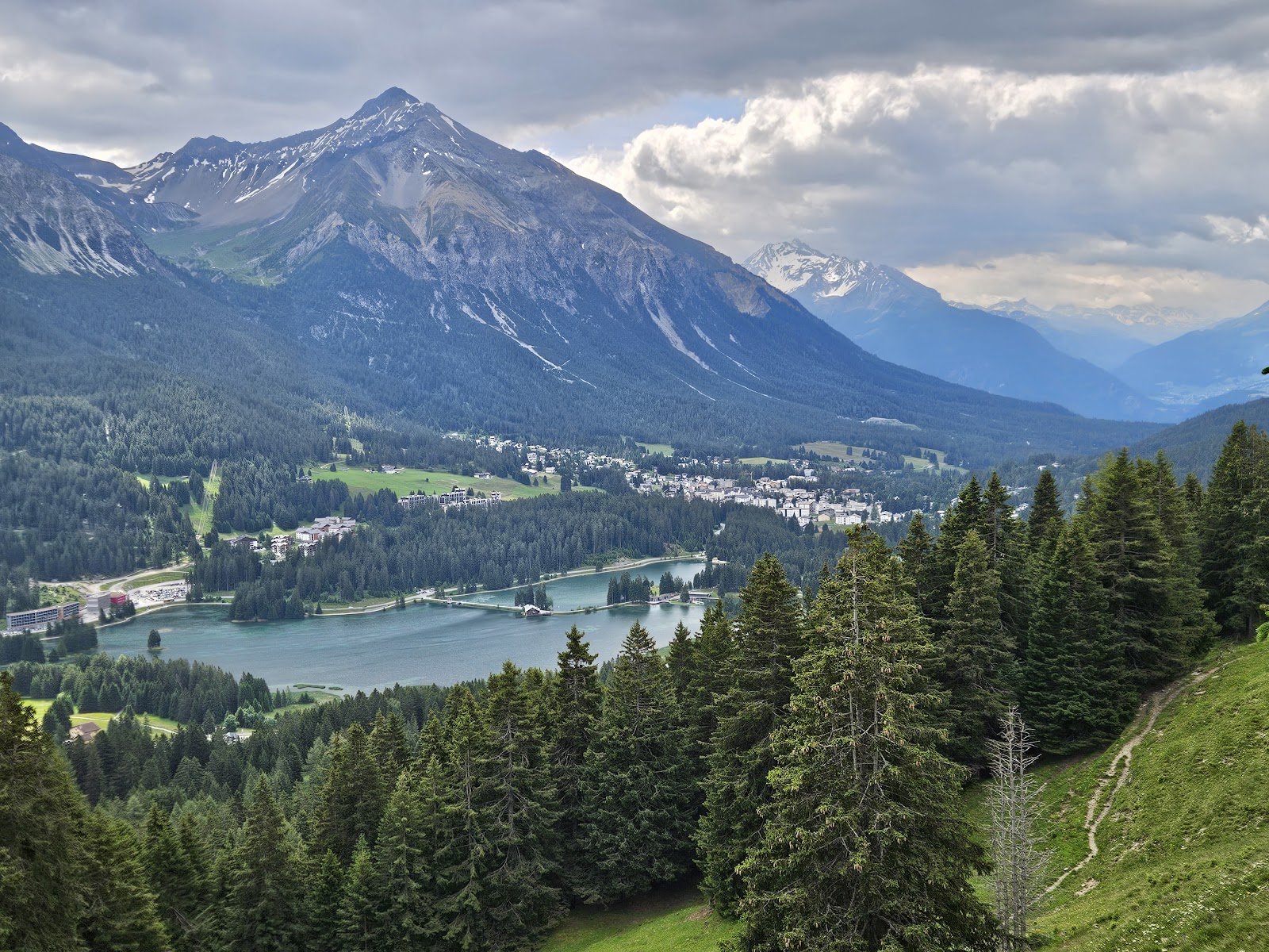 The sunny Lenzerheide plateau and frozen Heidsee lake under snow in Graubunden