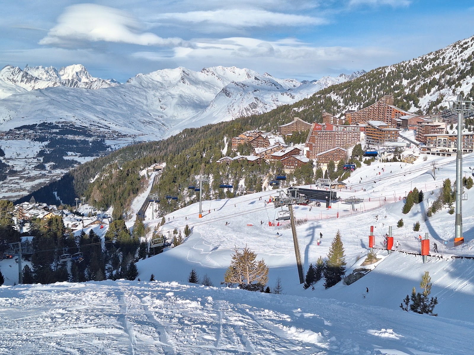 Tree lined pistes dropping toward Arc 1600 in soft light