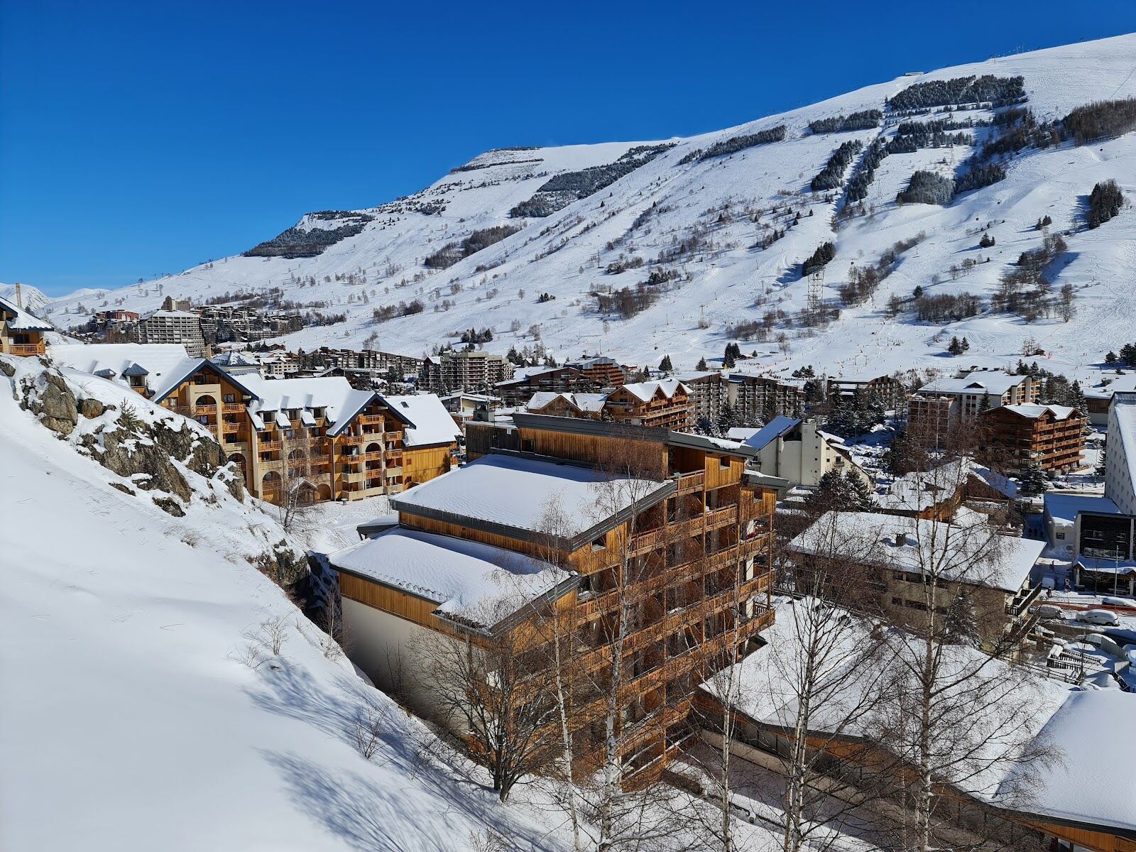 The long high street of Les Deux Alpes below its glacier under winter snow