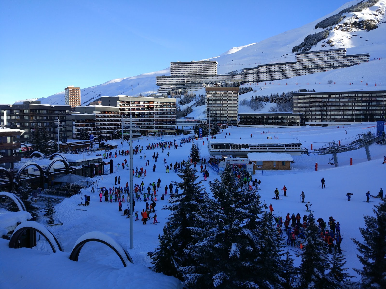 Skiers heading out from the village base of Les Menuires