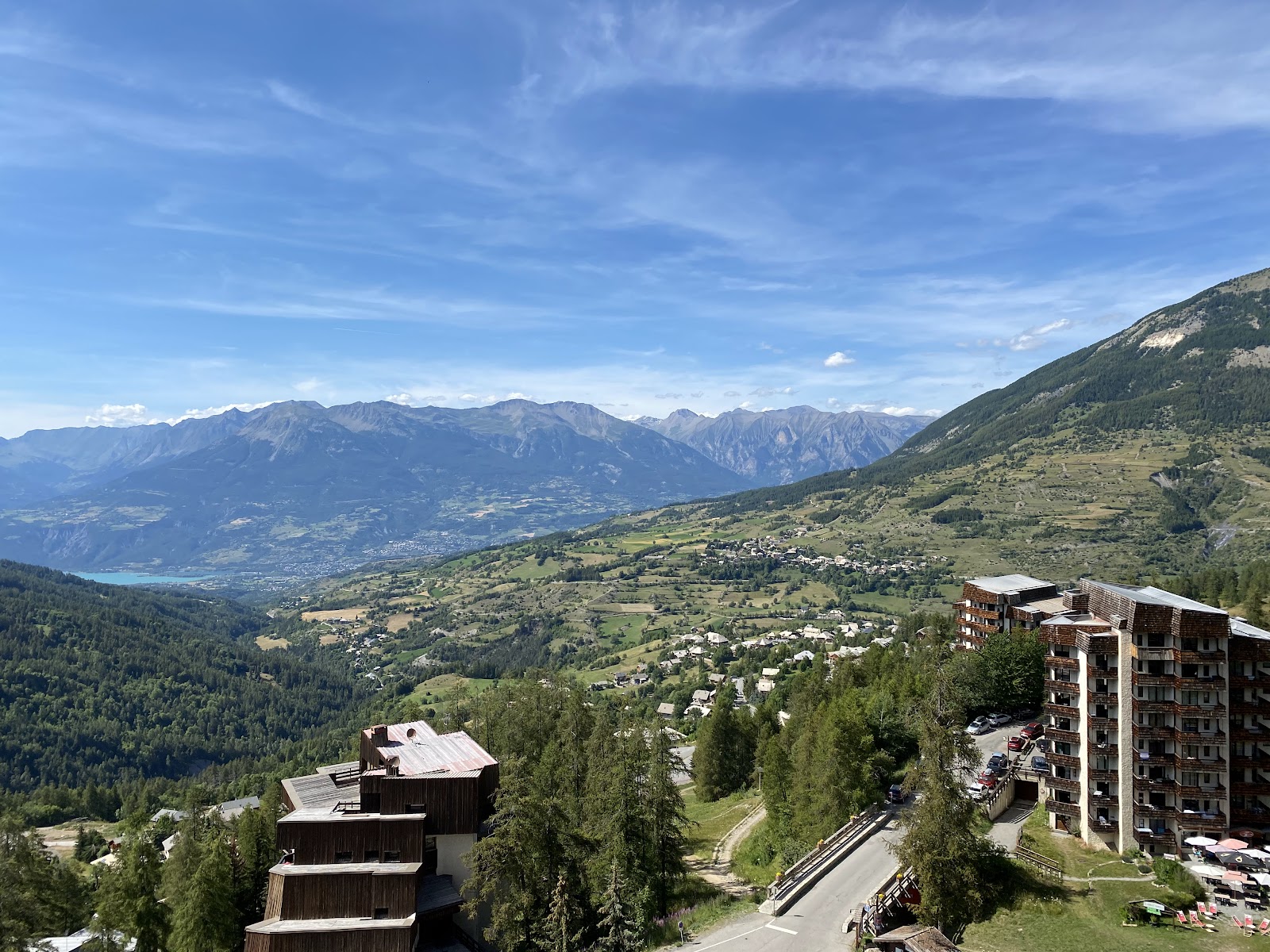 Forested pistes of Les Orres under blue sky