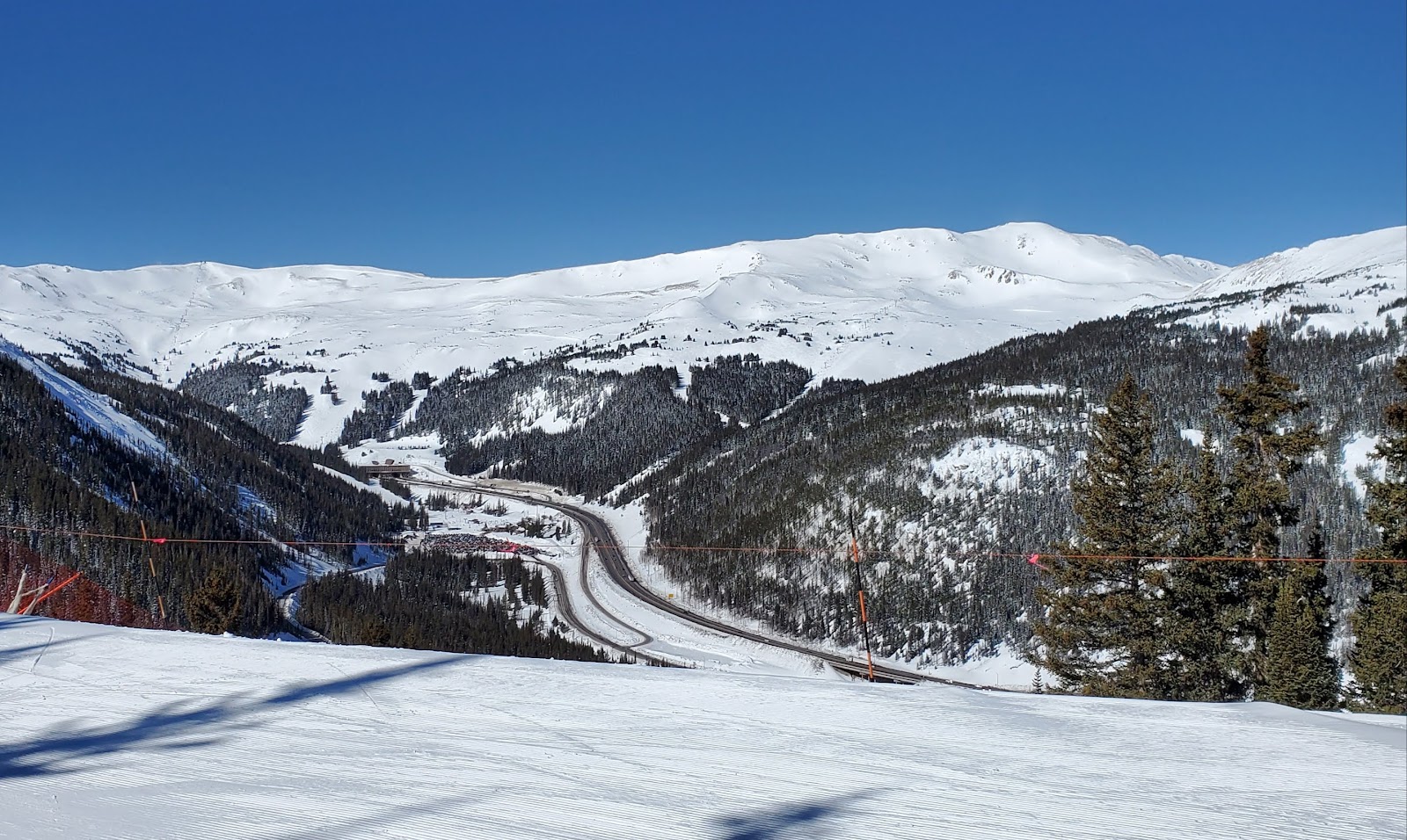 Skiers on a wide blue run at high altitude at Loveland