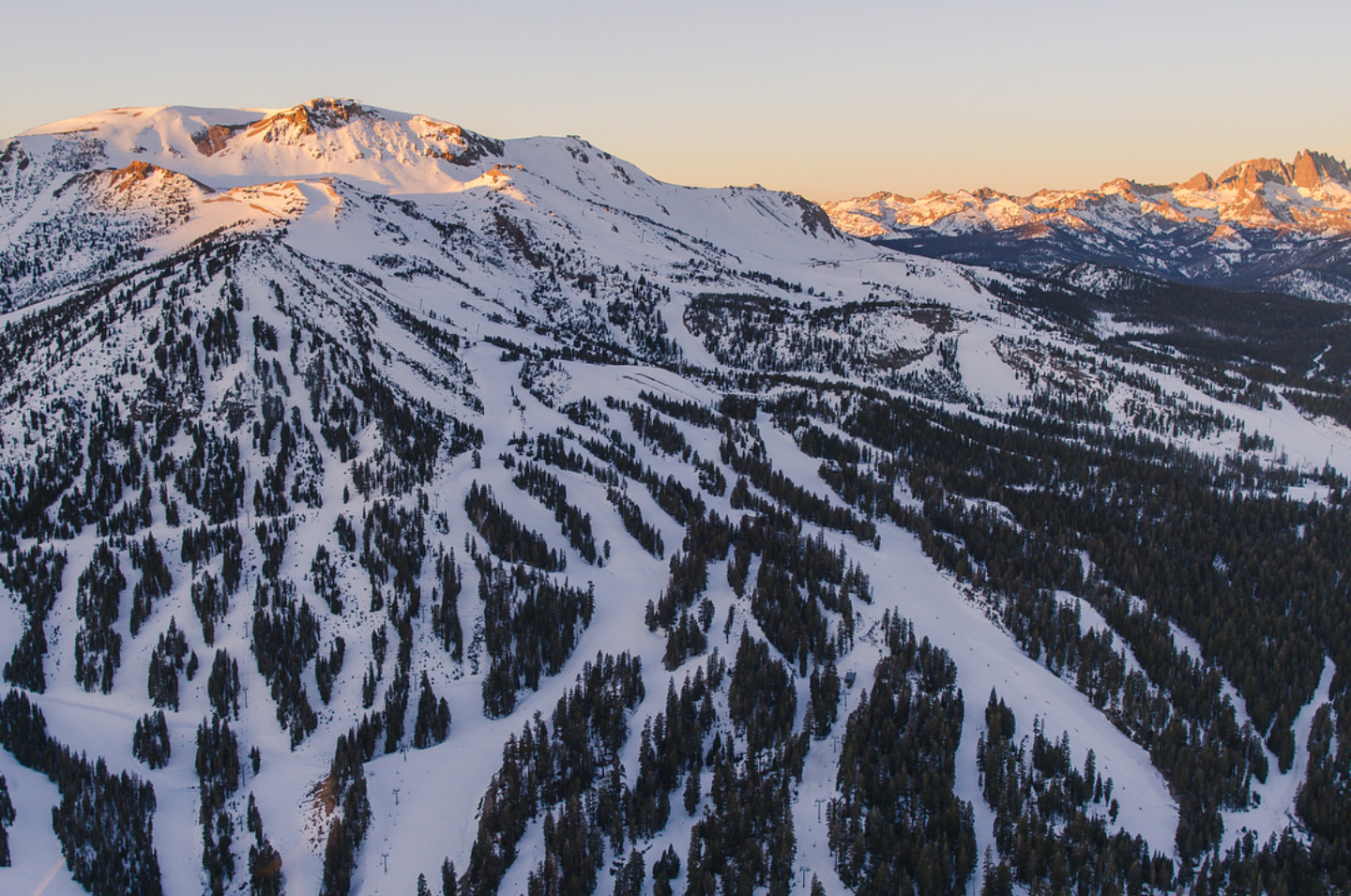 A skier carving a sunny groomed run high on Mammoth Mountain