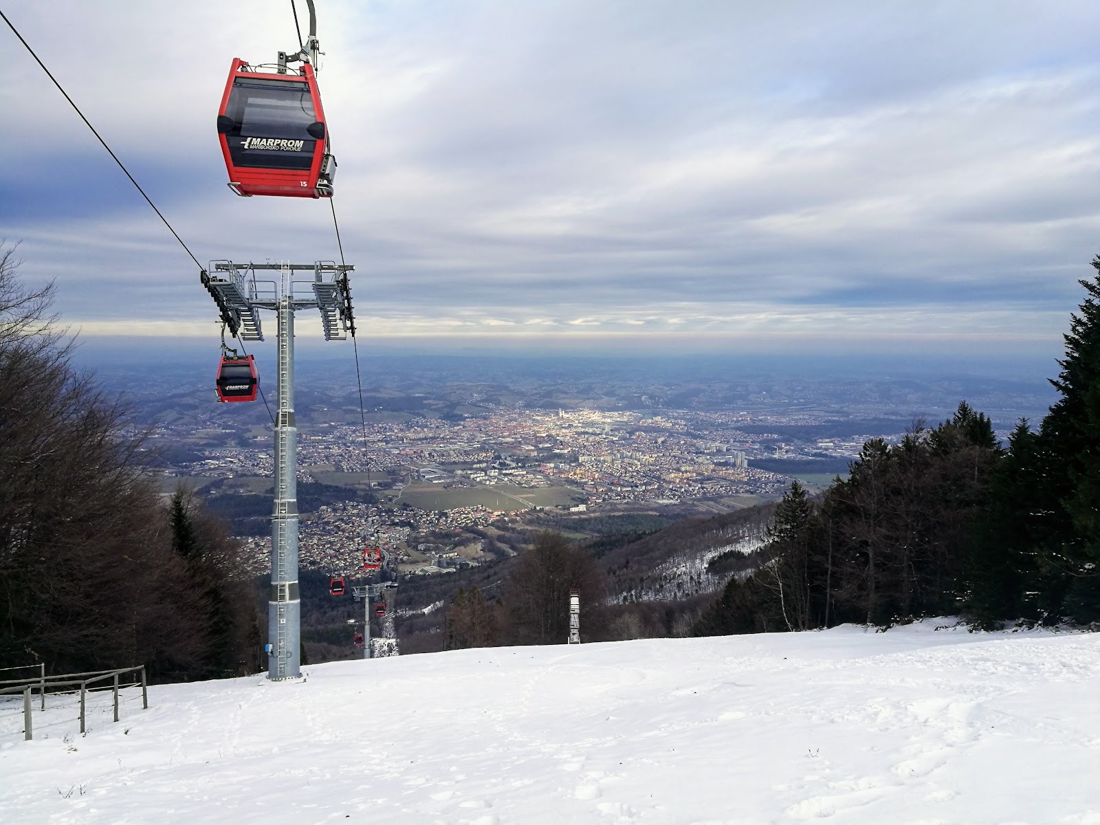 Skiers on a groomed intermediate run at Mariborsko Pohorje