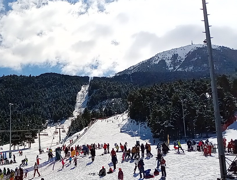 Skiers descending tree lined runs above the Cerdanya valley