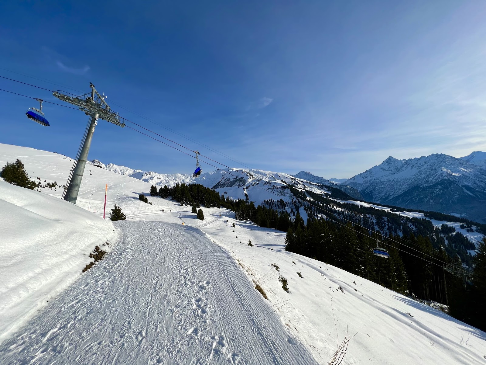 Skiers cruising the sunny Hasliberg slopes toward Planplatten