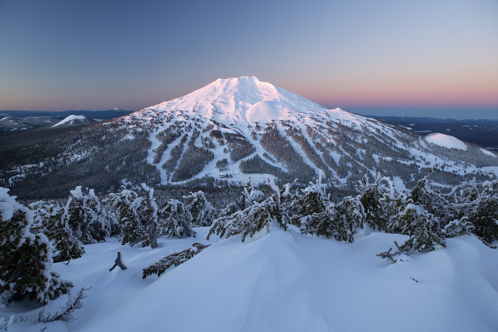 Skiers on a wide open bowl high on Mount Bachelor