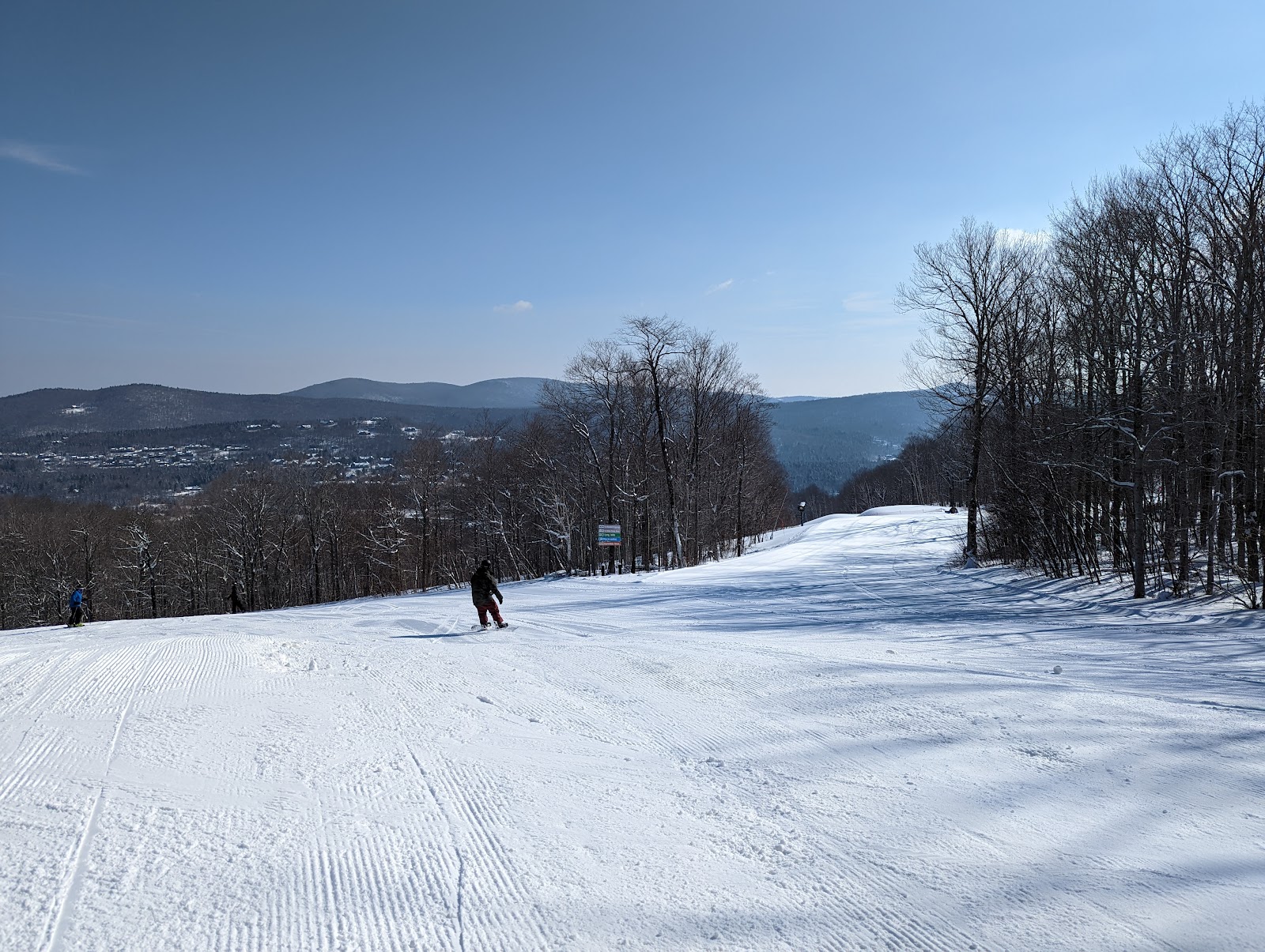 Groomed piste winding through snowy trees at Mount Snow