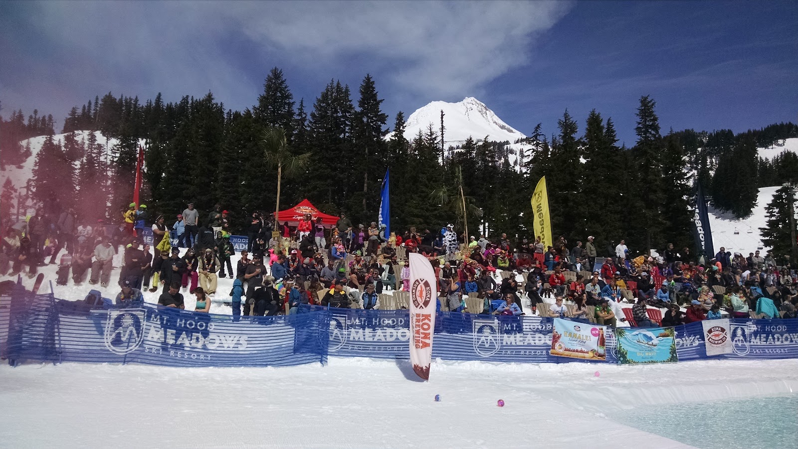Skiers below the snowy upper terrain of Mt Hood Meadows