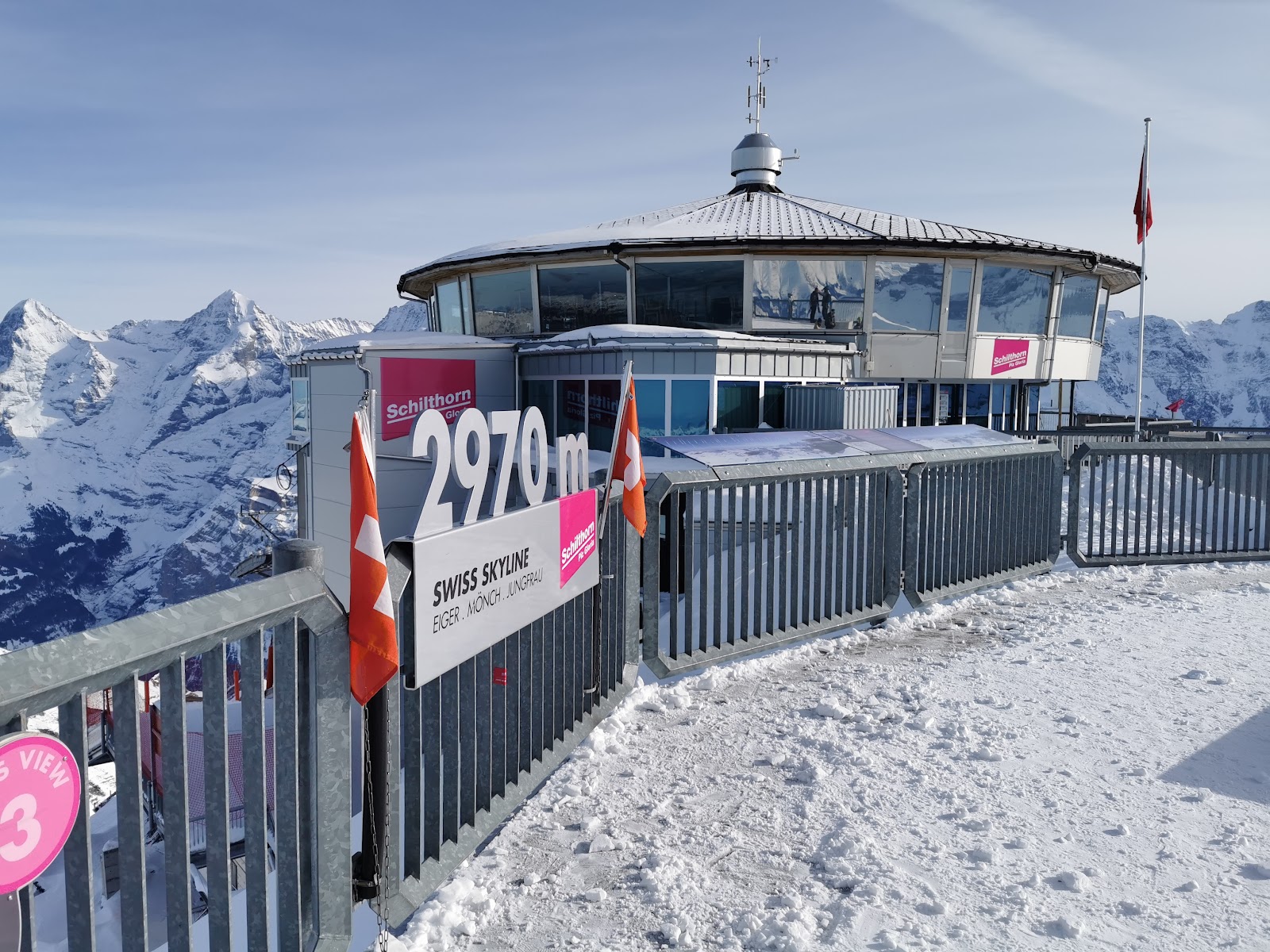 Skiers on a piste above Murren with the high peaks behind