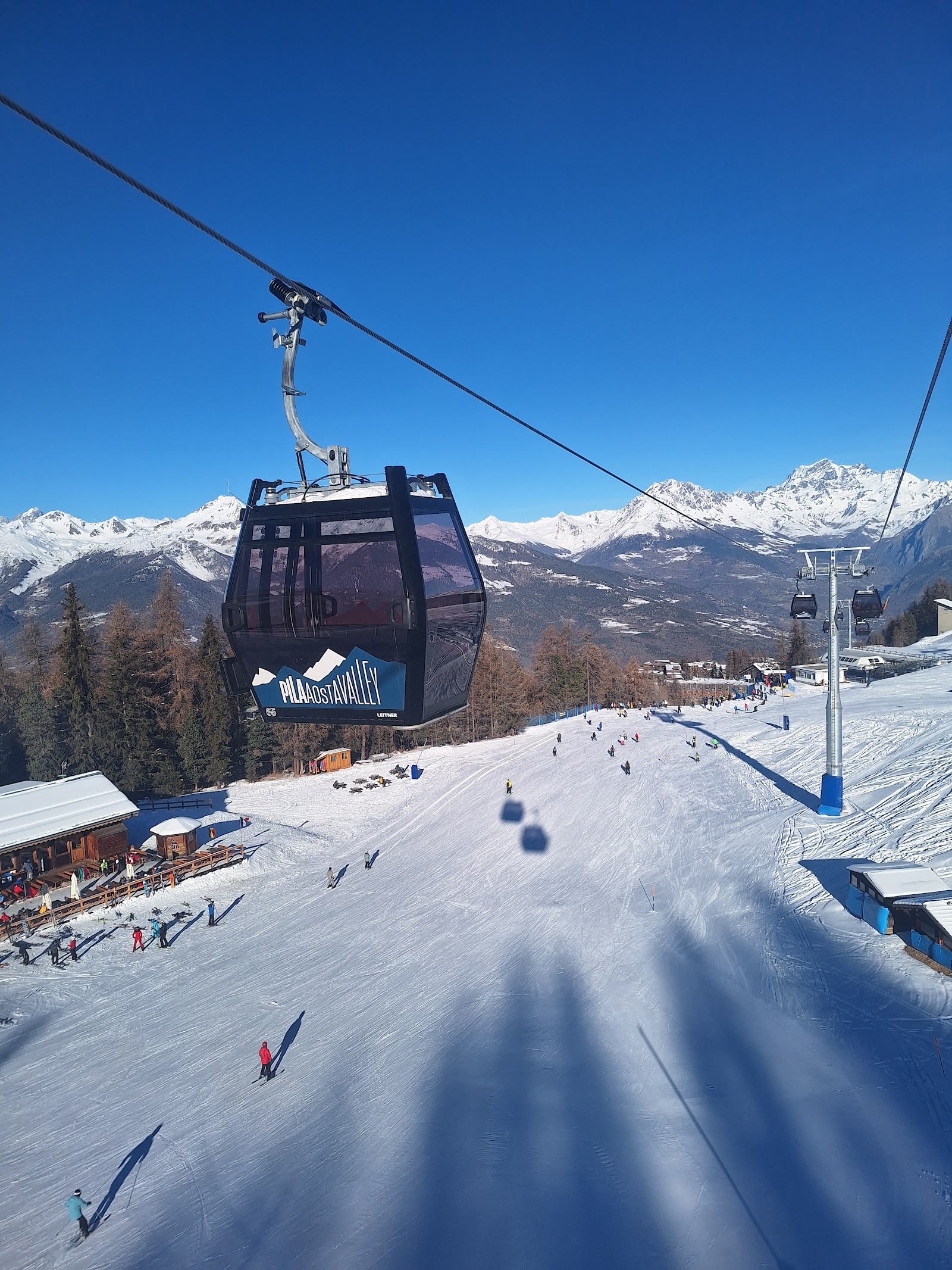 Wide sunny intermediate pistes above the Aosta Valley at Pila