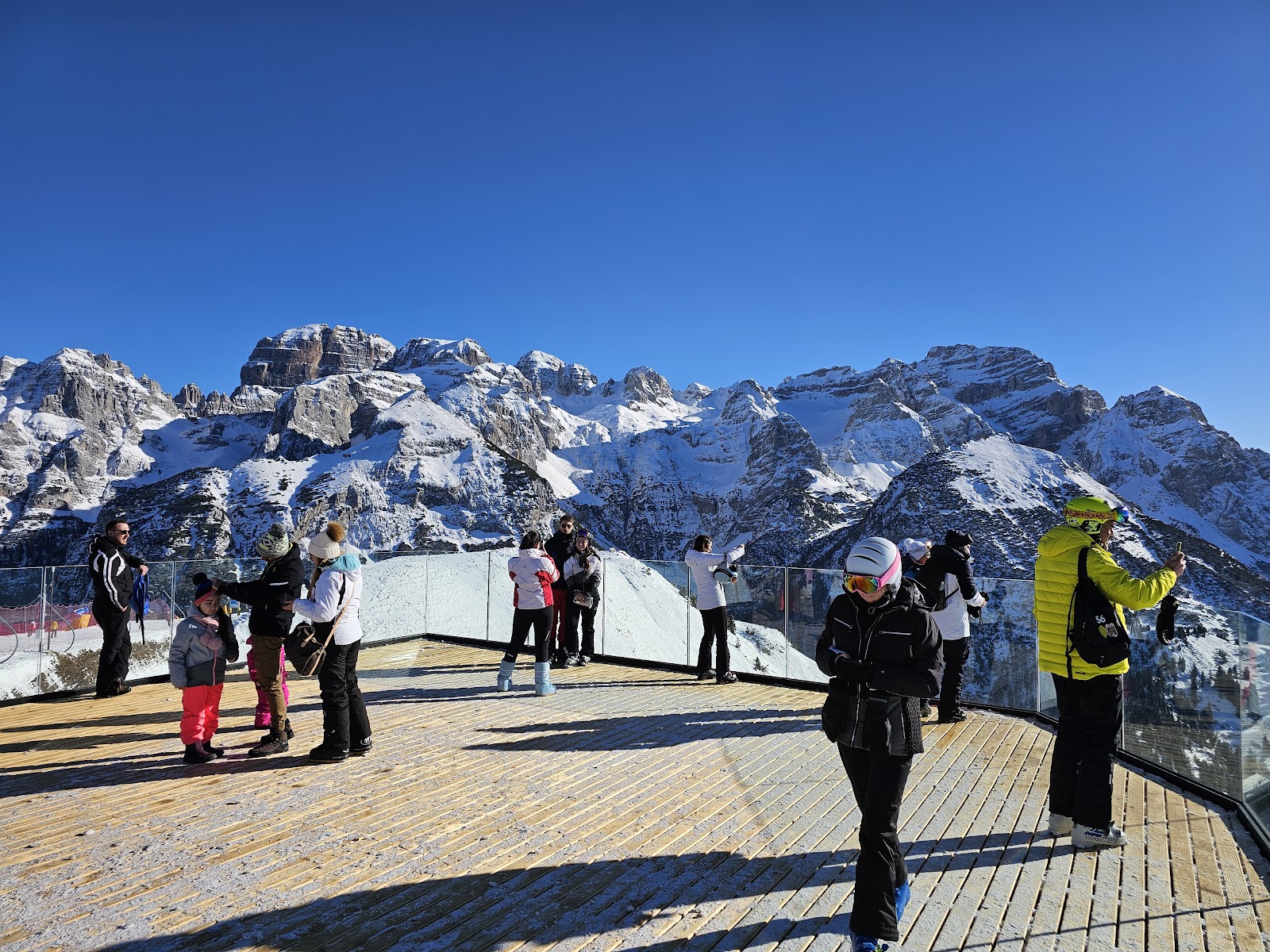 Skiers cruising a wide well groomed run in the mountains