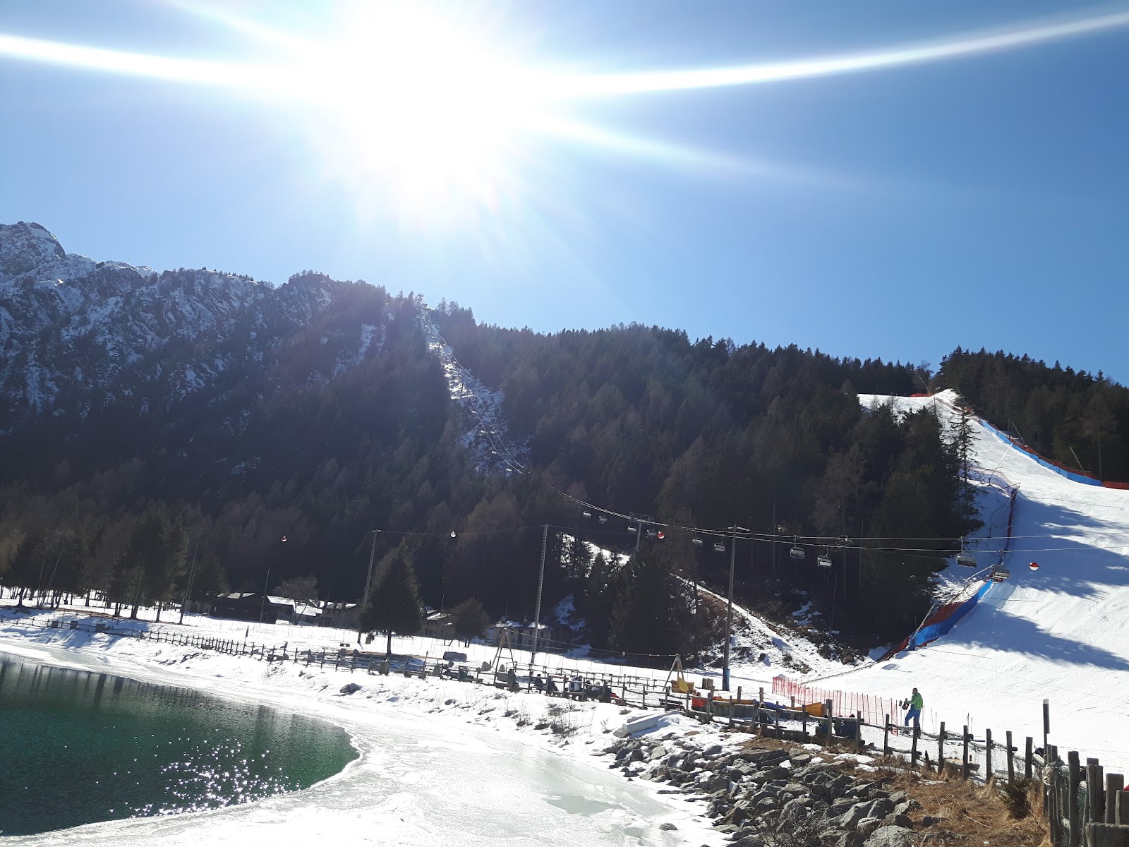 Skiers cruising a wide groomed run in the Italian Alps