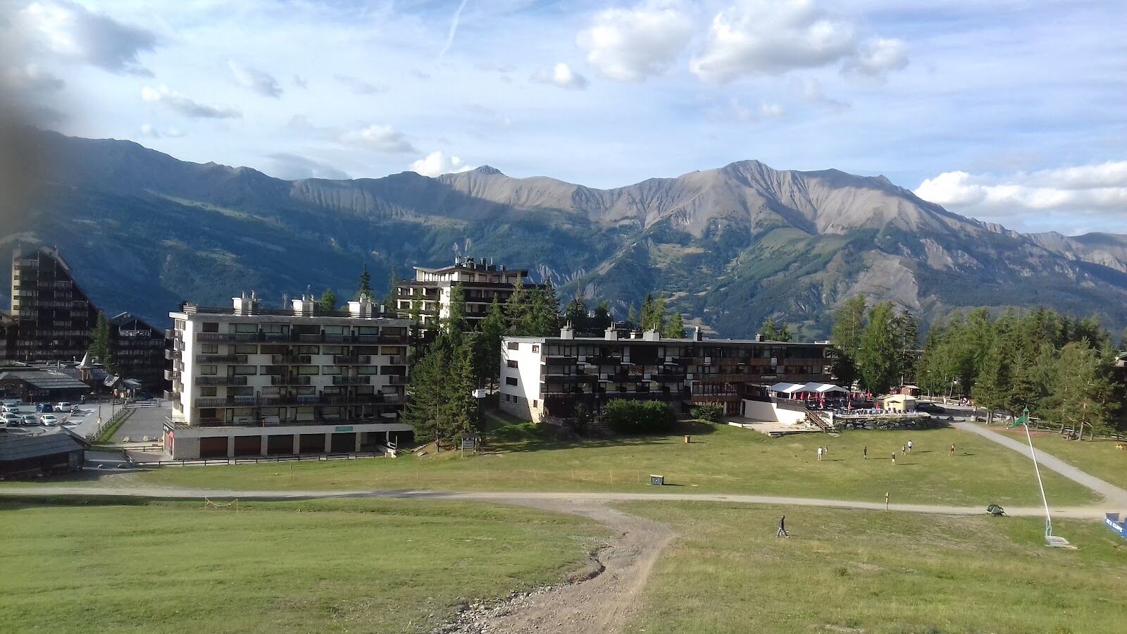 Pra Loup resort and larch forest under a sunny southern Alps sky