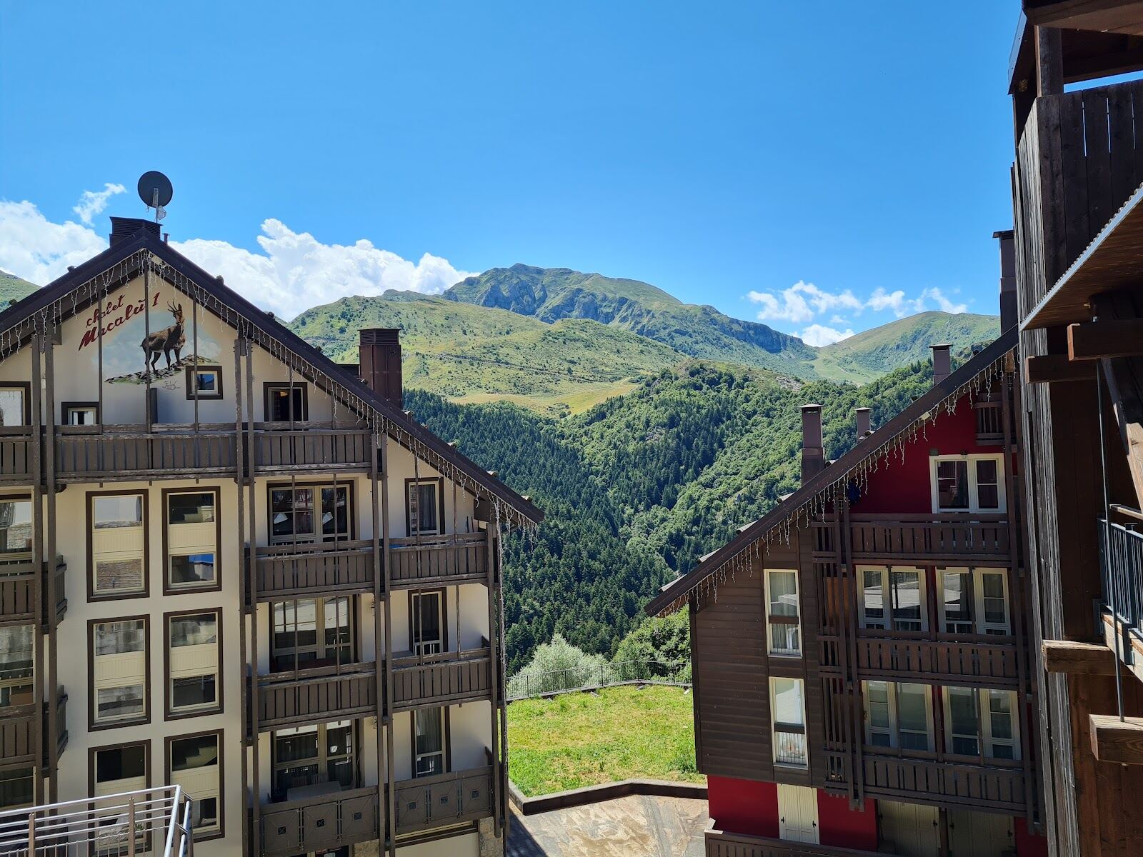 Sunny wide beginner slopes at Prato Nevoso with apartments beside the piste
